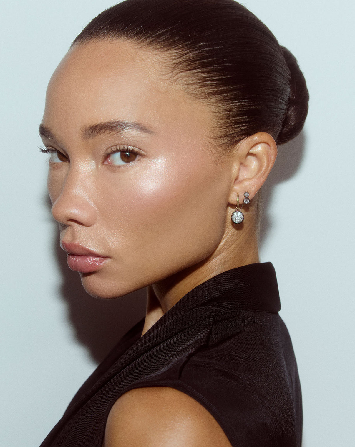 Detail view of 14k gold Georgian lab diamond stud earrings being worn on ear