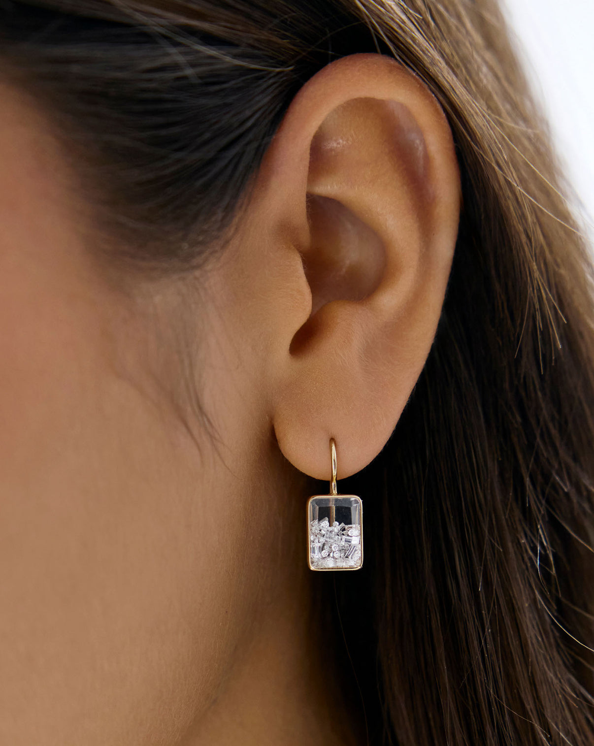 Close up view of model wearing Shaker Emerald Drop Earring.