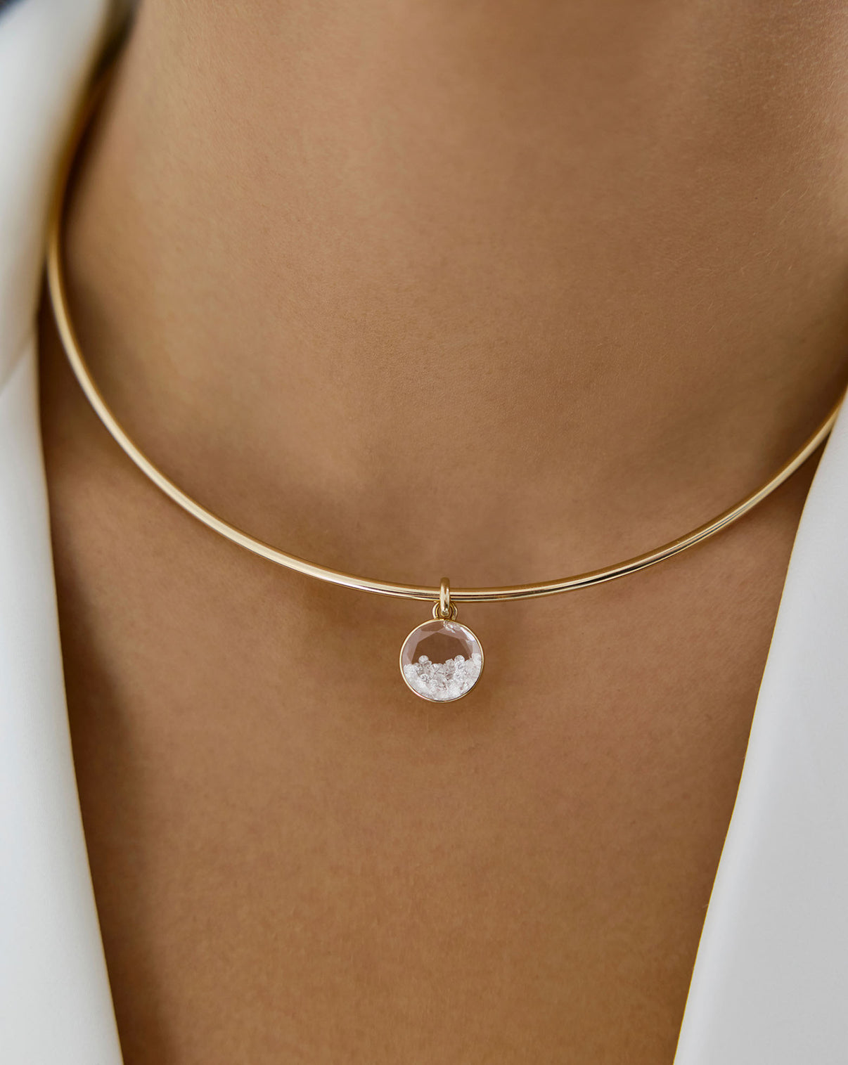 Close up view of model wearing Shaker Round Pendant on gold necklace.