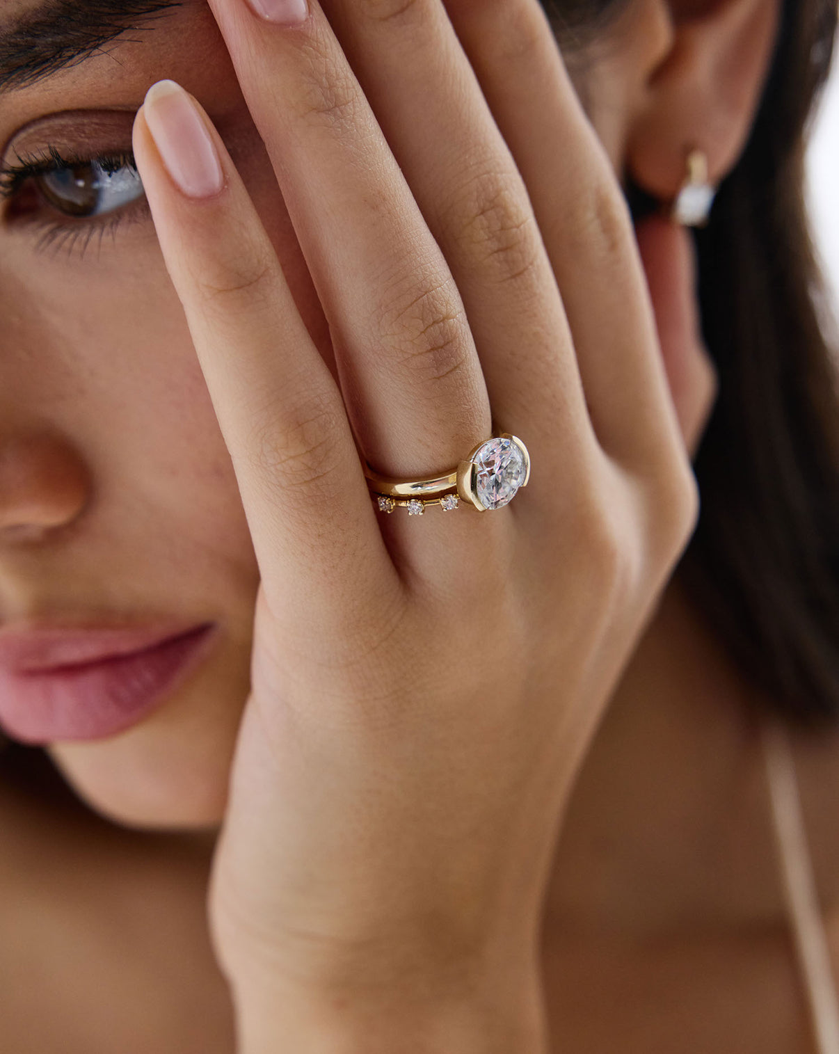 Close up view of model wearing Lab Diamond Station Wedding Band stacked with diamond ring GLOBAL