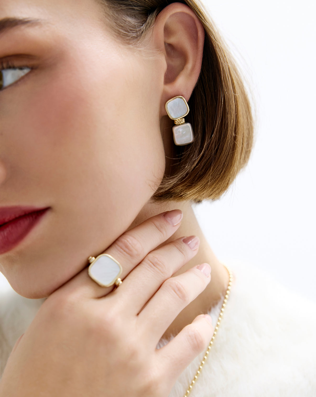 Model wearing square pearl earrings showcasing 14k solid gold details.