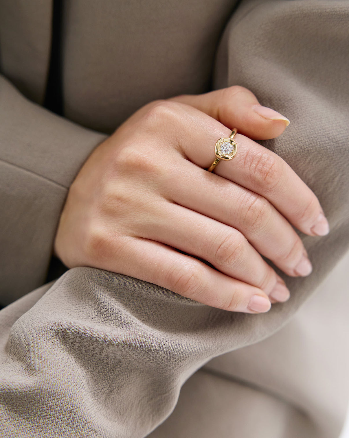 Close-up of Organic Shapes Center Stone Ring worn on finger showing 14k gold setting and diamond details