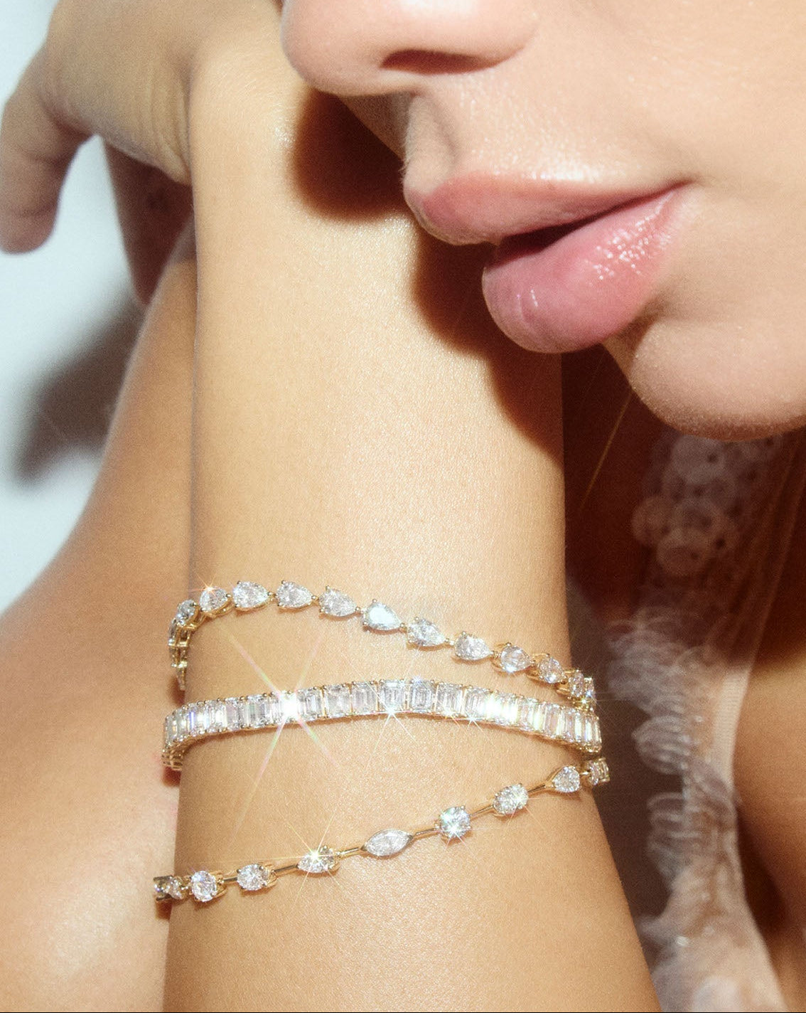 Detailed view of emerald lab diamond tennis bracelet with 14k solid gold being worn by model on their wrist