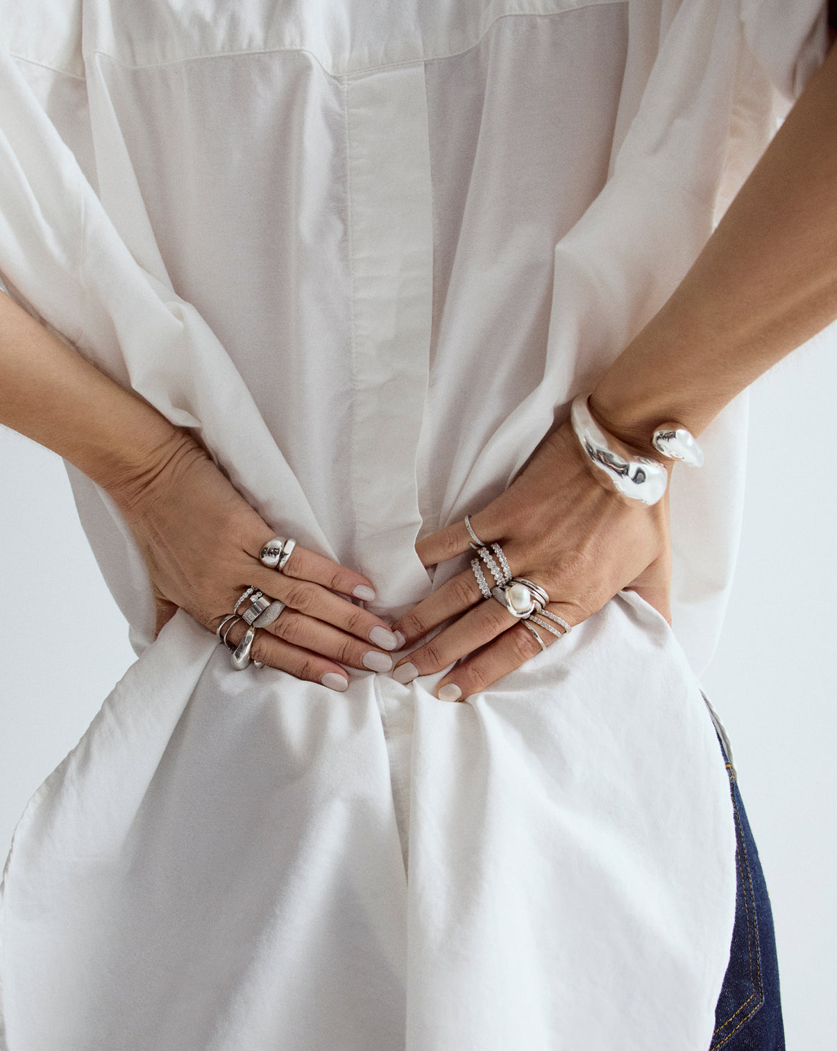 Woman wearing Coco Curved Bangle in Silver, elegant lifestyle photography