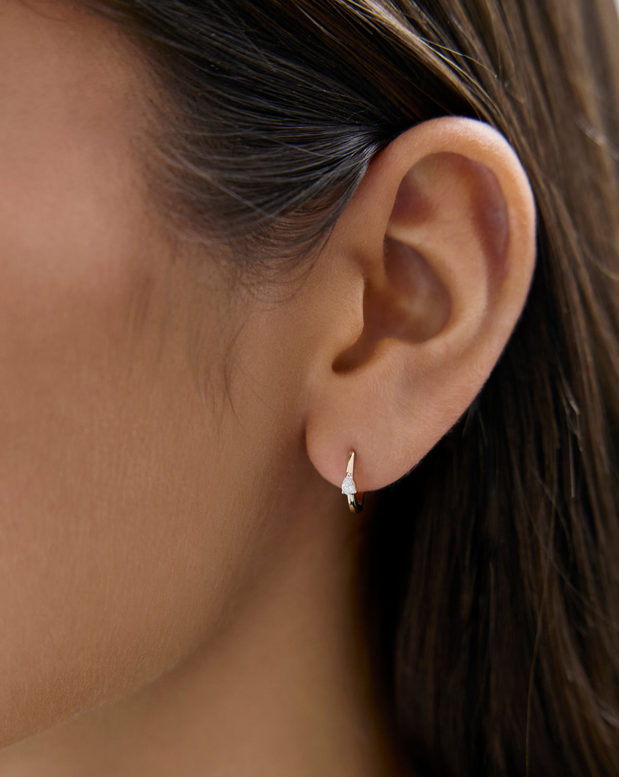 Mini Pear Huggies by Ring Concierge Holiday Gifting Collection - Lifestyle shot of gold and diamond hoop earrings