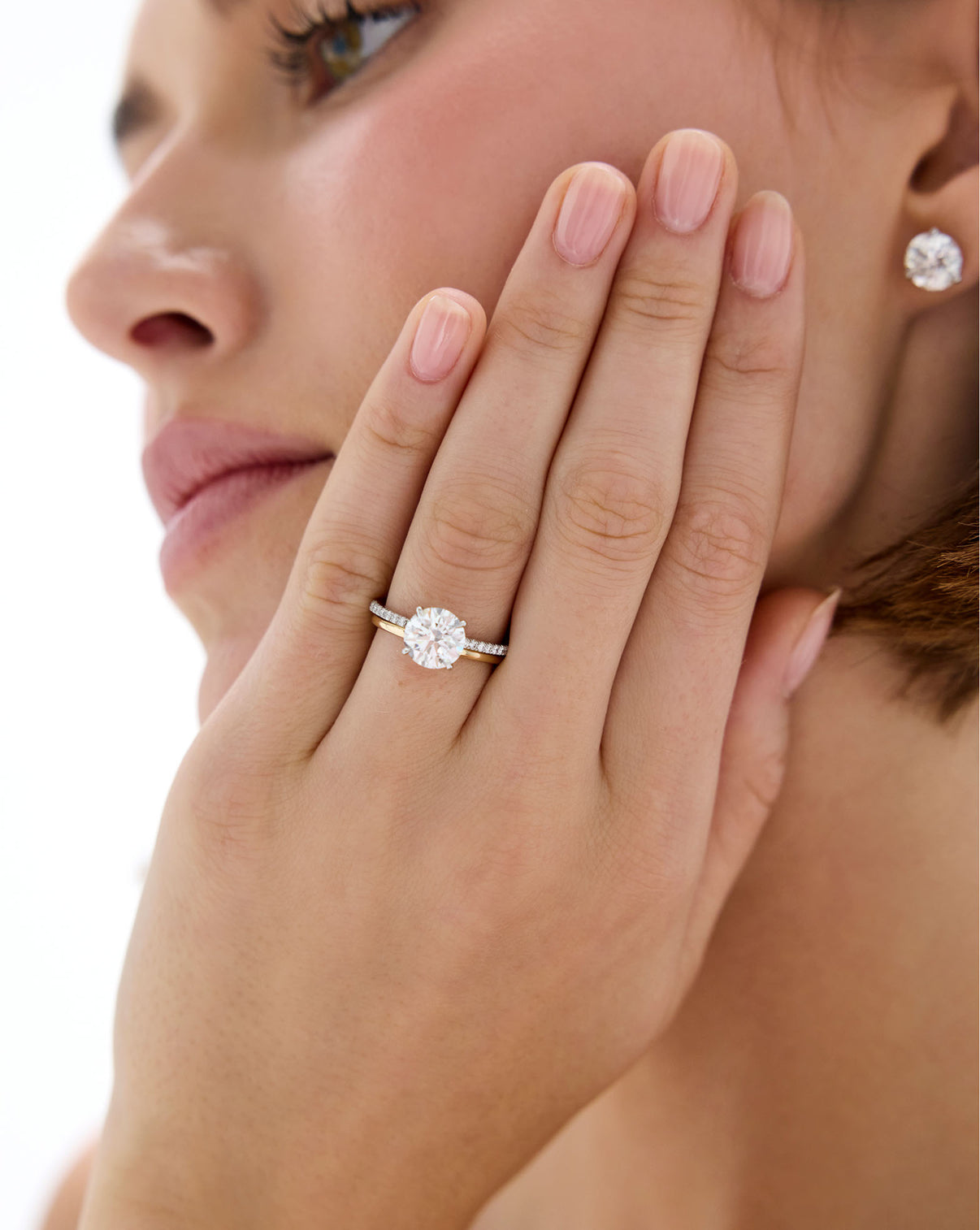 Model wearing 14K Yellow Gold Whisper Thin Band stacked with a Round Engagement Ring set in Whisper Thin Pave