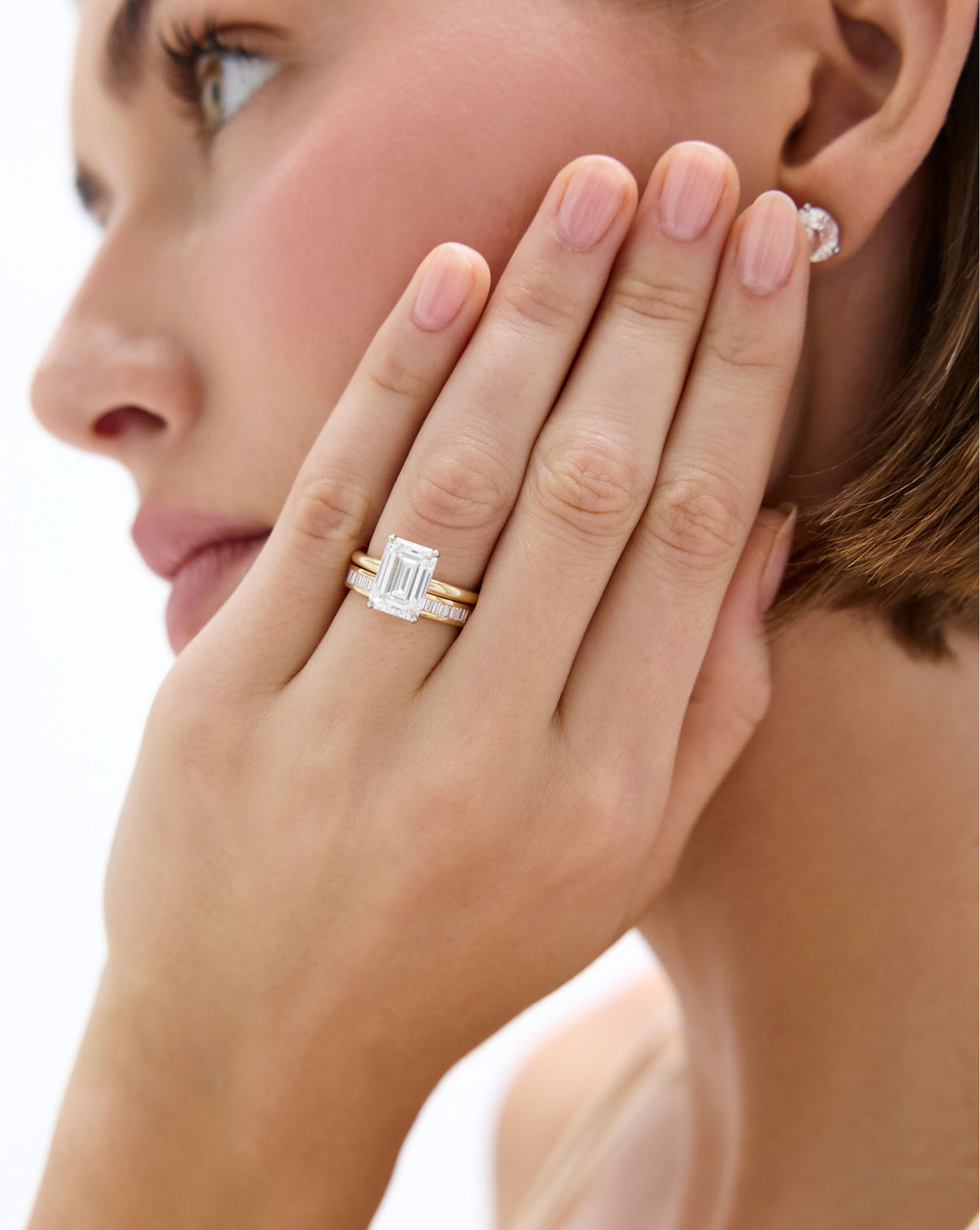 Model wearing Baguette Diamond Channel Set Band in 14K Yellow Gold stacked with an engagement ring