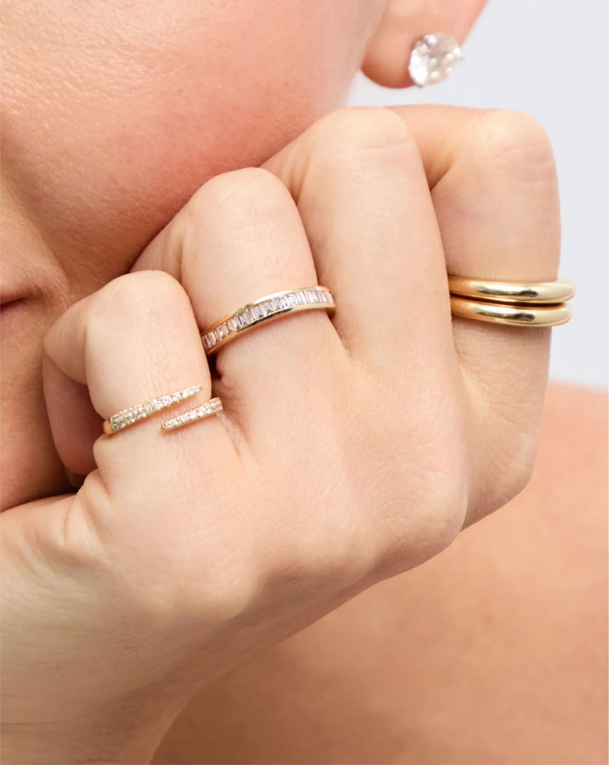 Model wearing Baguette Diamond Channel Set Band in 14K Yellow Gold along with other gold and diamond rings