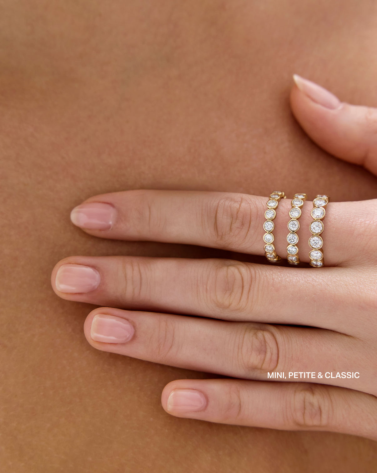 model wearing Mini, Petite, and Classic Round Bezel Eternity Band on one finger to show size comparison global