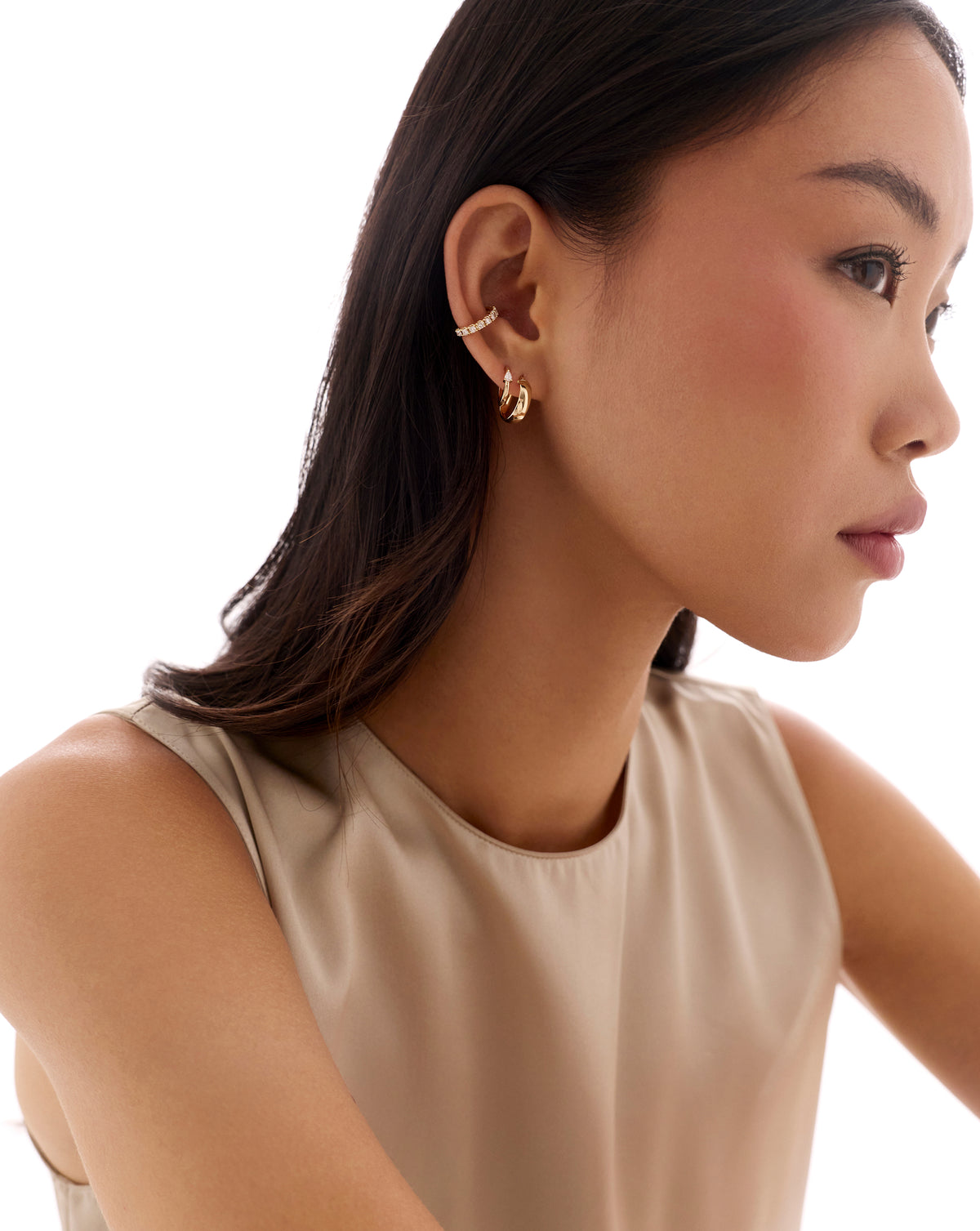 14k yellow gold jumbo diamond ear cuff worn on the upper ear, paired with small gold hoop earrings in a clean lifestyle shot.