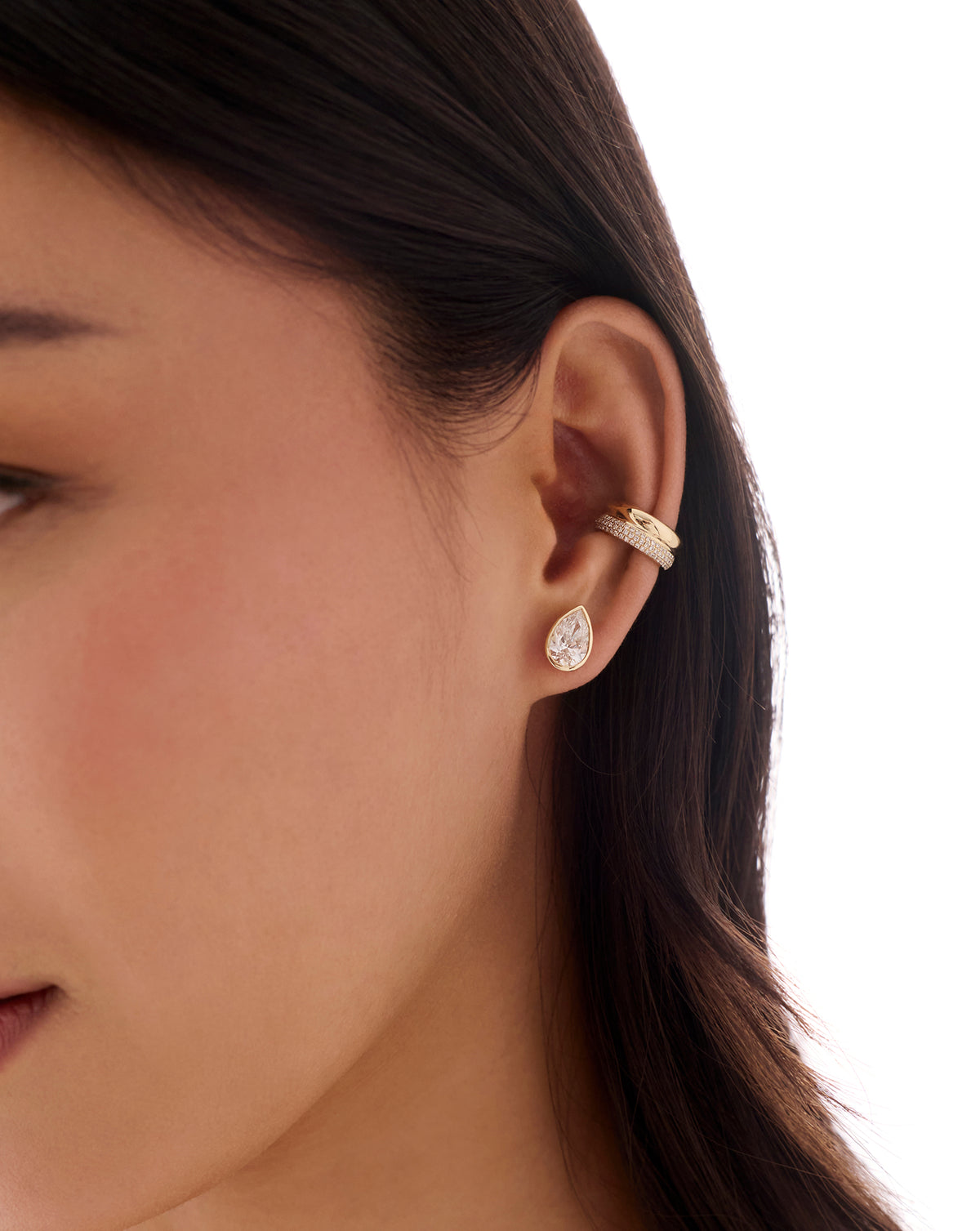 Gold double-row pavé ear cuff with sparkling clear stones worn on the upper ear, paired with a teardrop stud earring.