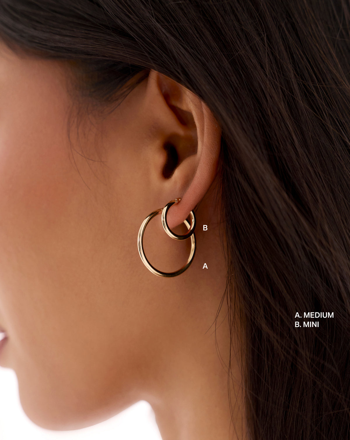 global essential hoop earrings shown in medium and mini sizes, worn together on the ear for a side-by-side size comparison.