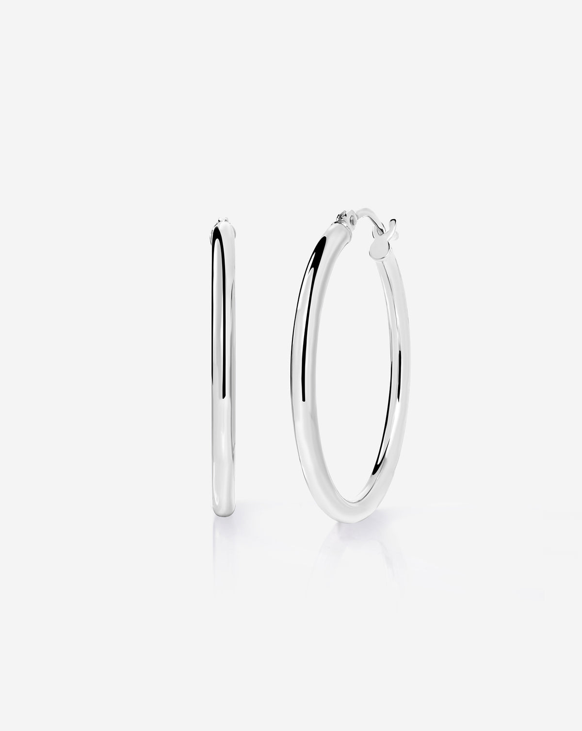 Sterling silver essential medium hoop earrings with a classic rounded design and hinged closure, displayed on a white background.