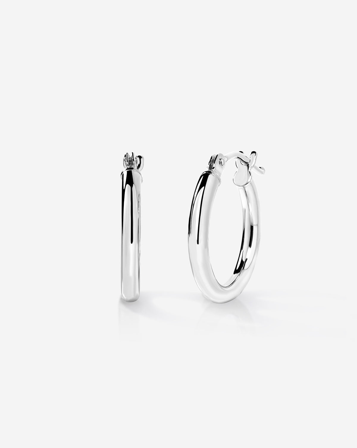 Sterling silver essential mini hoop earrings with a classic rounded design and hinged closure, displayed on a white background.