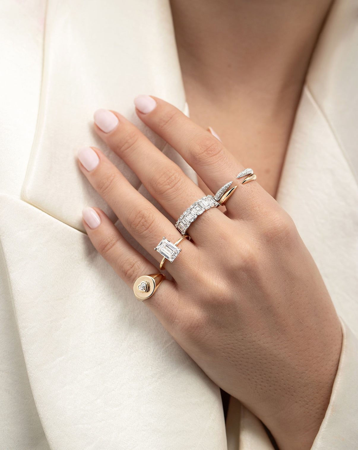 Triple Row Diamond Claw Ring stacked on pointer finger with gold claw ring and other rings on model's hand