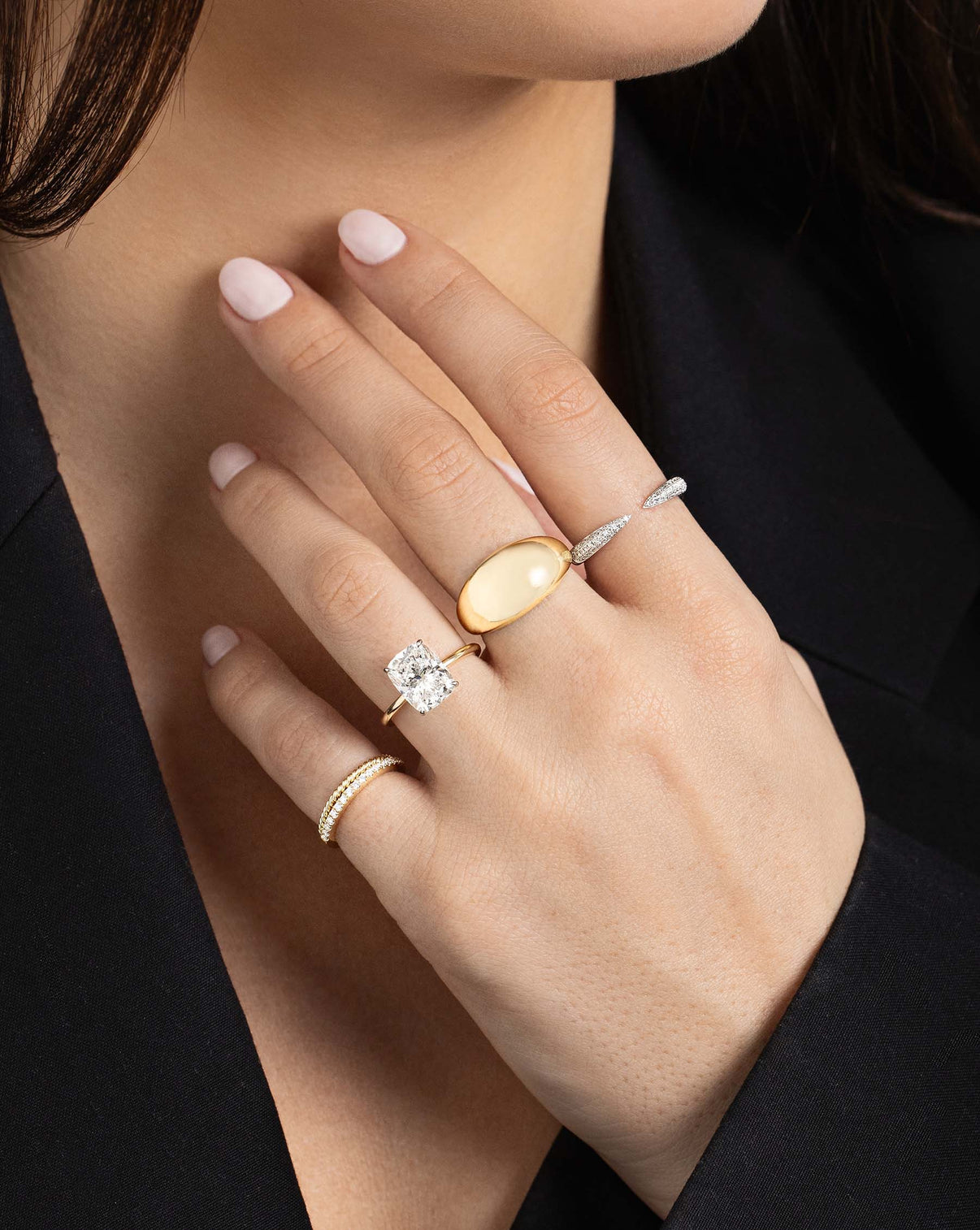 Triple Row Diamond Claw Ring on model's pointer finger styled with Jumbo Gold Cloud Ring, Engagement Ring and two gold rings on pinky finger