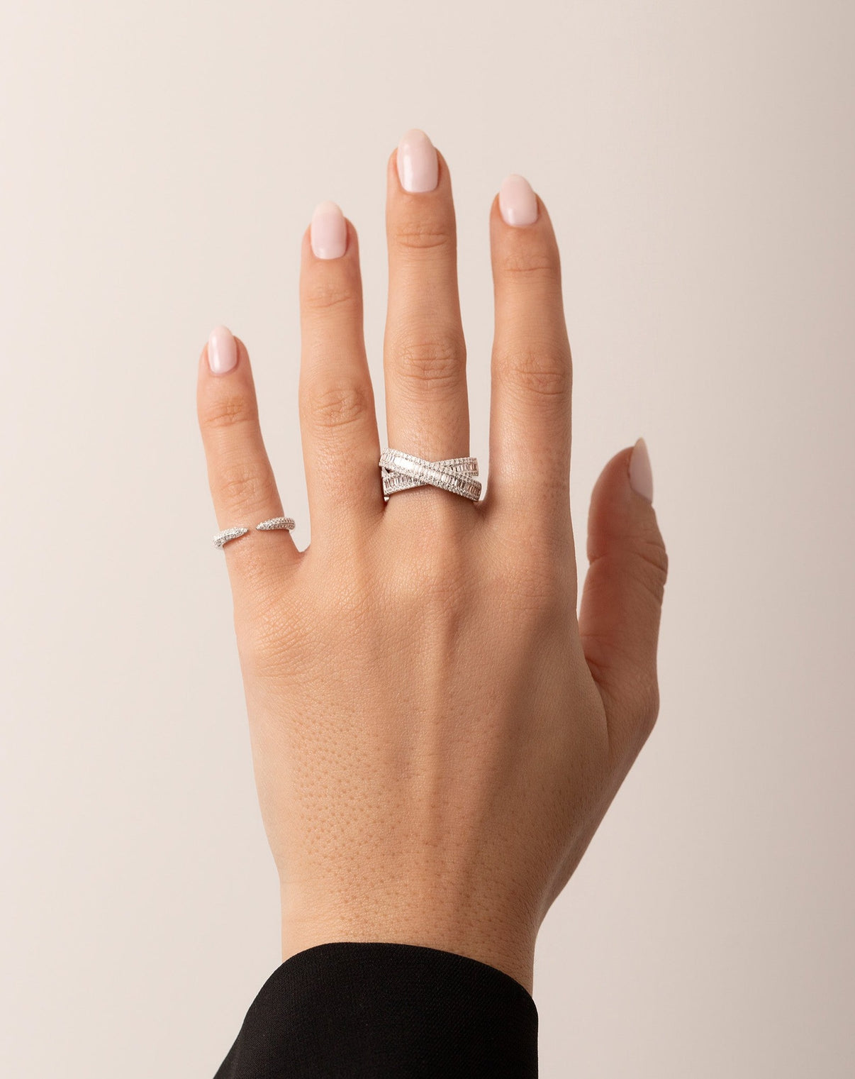 Triple Row Diamond Claw Ring on pinky styled with the Petite Baguette Crossover Ring on model hand