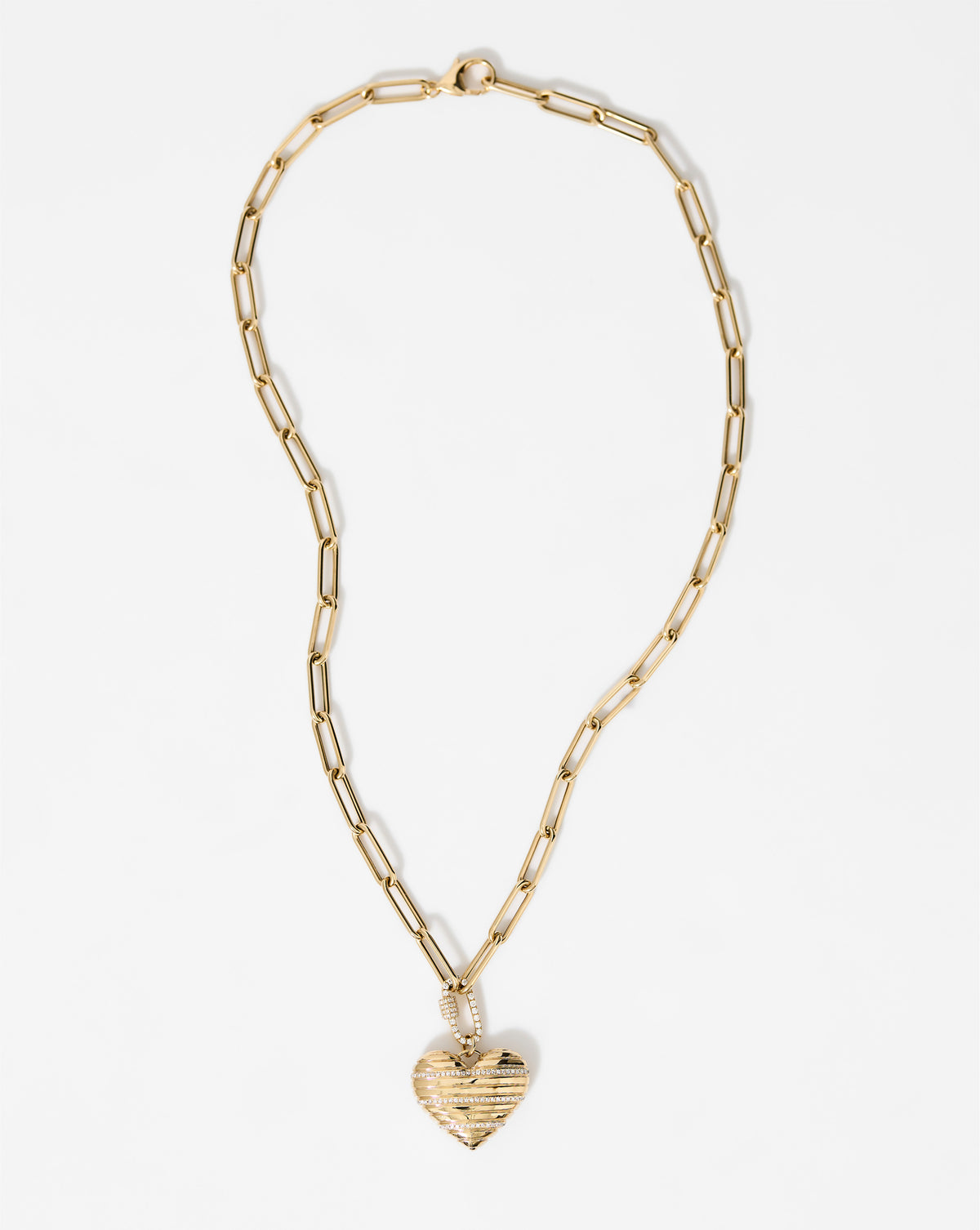 flat lay image of heart pendant with chain in yellow gold