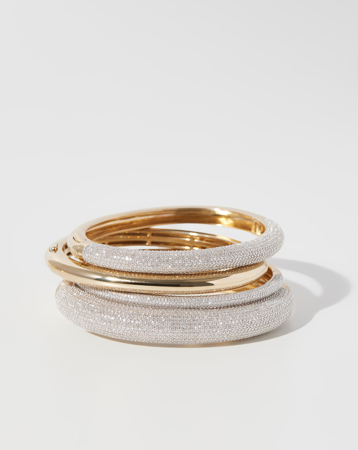 Pavé Diamond Stackable Gold Cloud Bangles and Stackable Gold Cloud Bangles stacked on top of each other in 1 pile - global