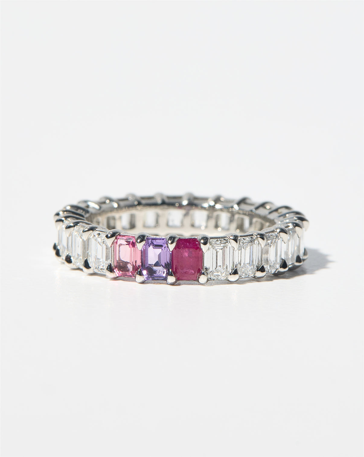 emerald diamond and birthstone eternity band against white background platinum