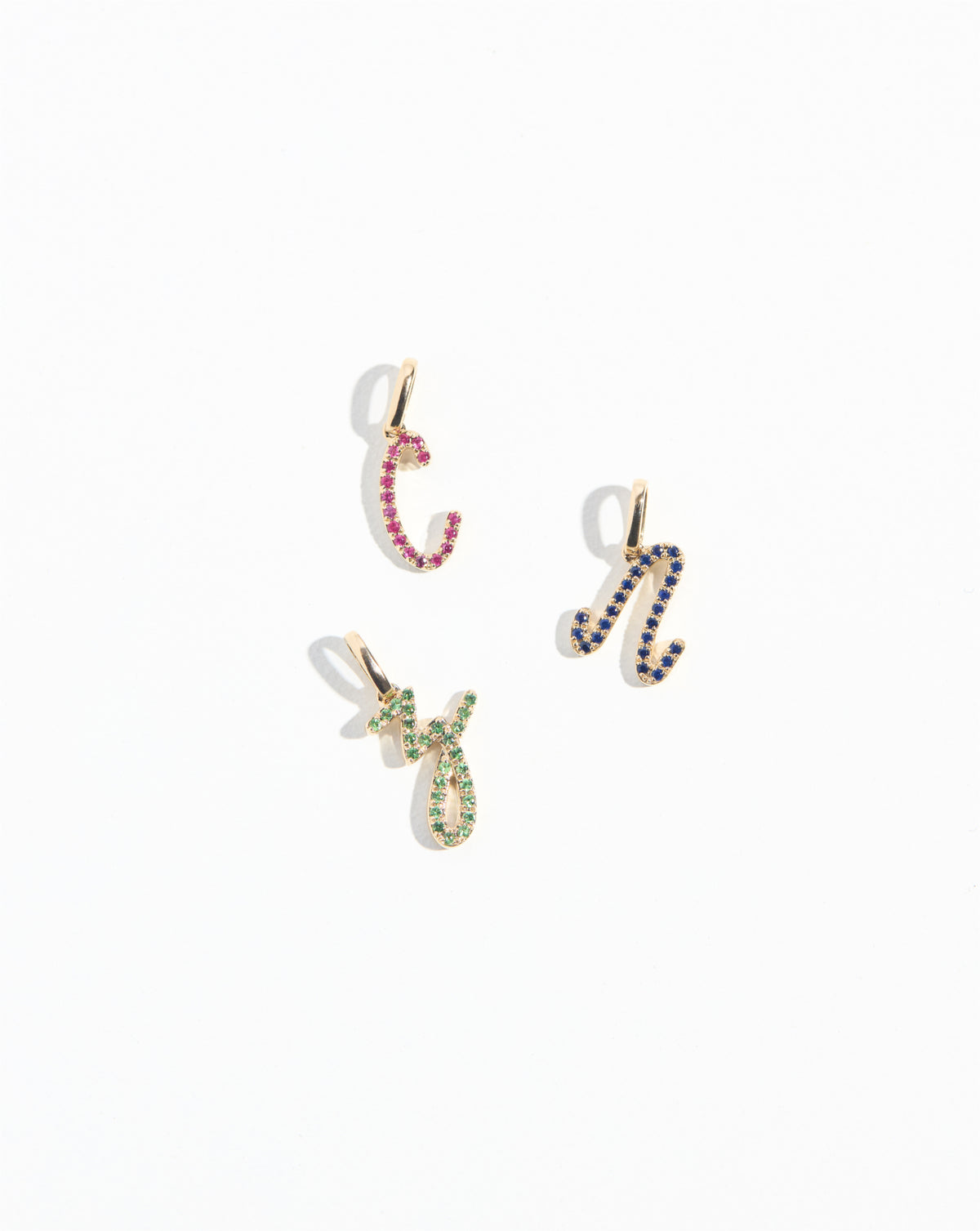 Gemstone Script Initial Pendants letters Z, C and N scattered on white background