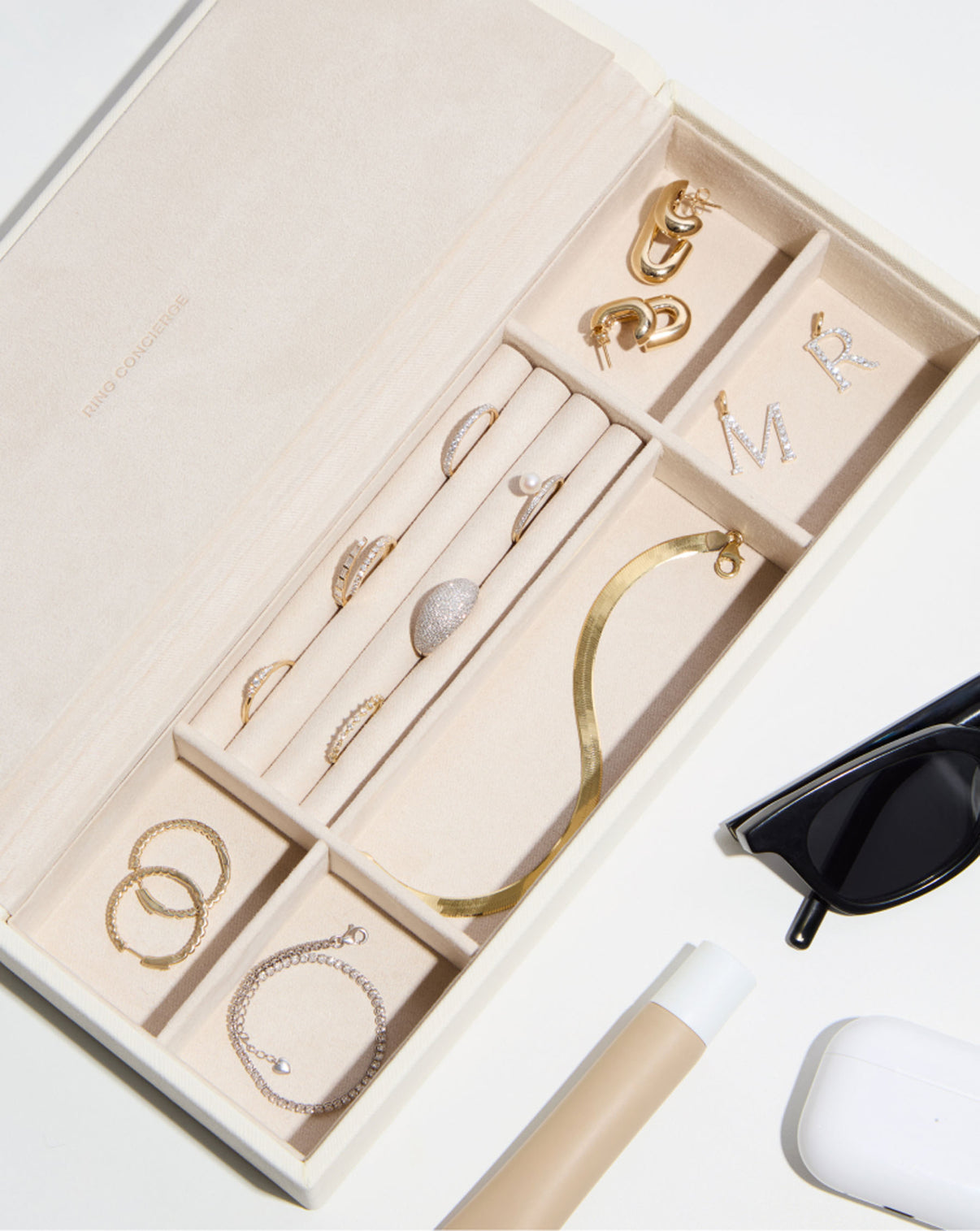 Leather Jewelry Box bird's eye angle with jewelry in compartments and sunglasses, lip gloss and headphones case outside box
