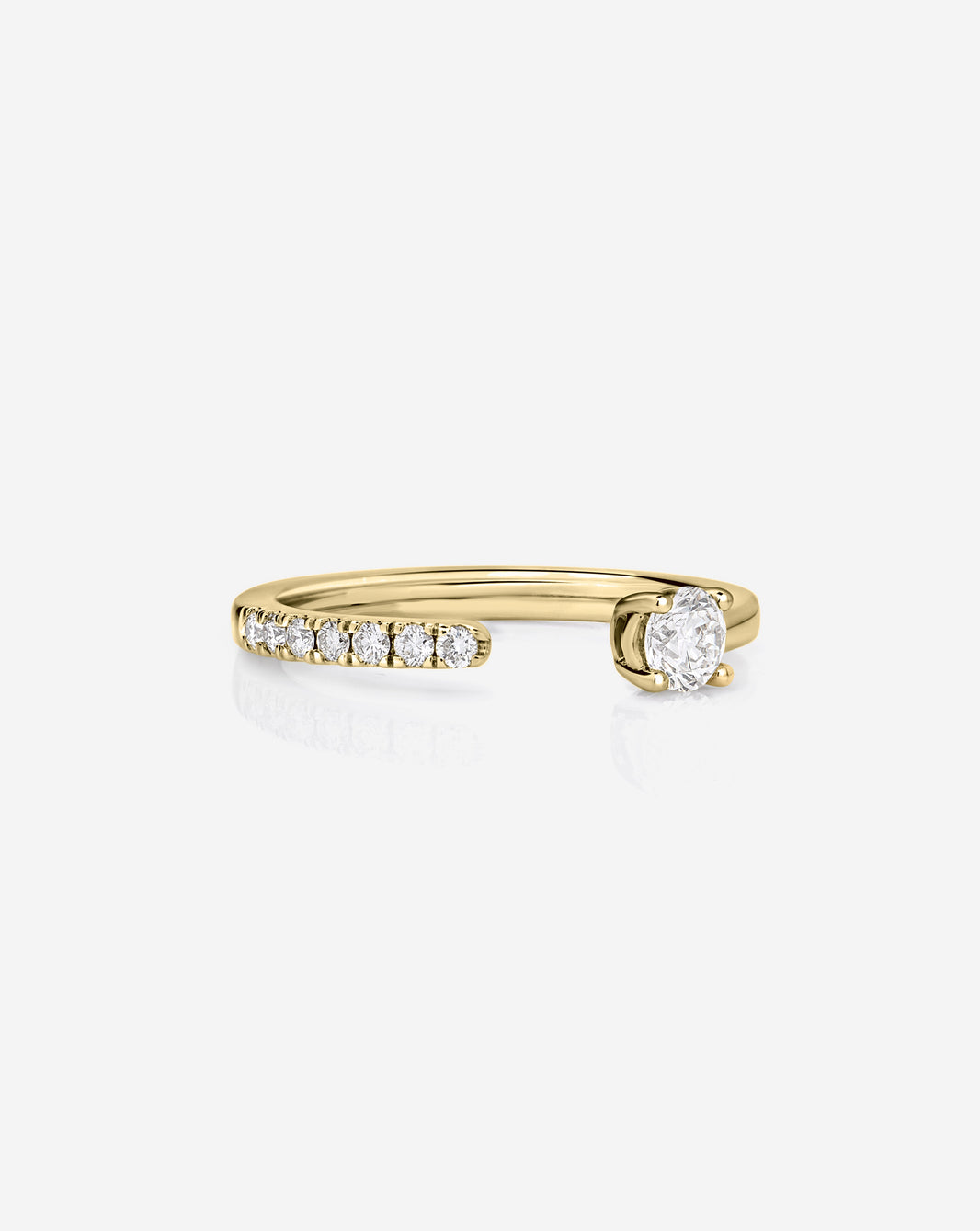 A 14k yellow gold open band ring featuring ak row of small round-cut diamonds on one side and a larger oval diamond on the other, set against a clean white background.