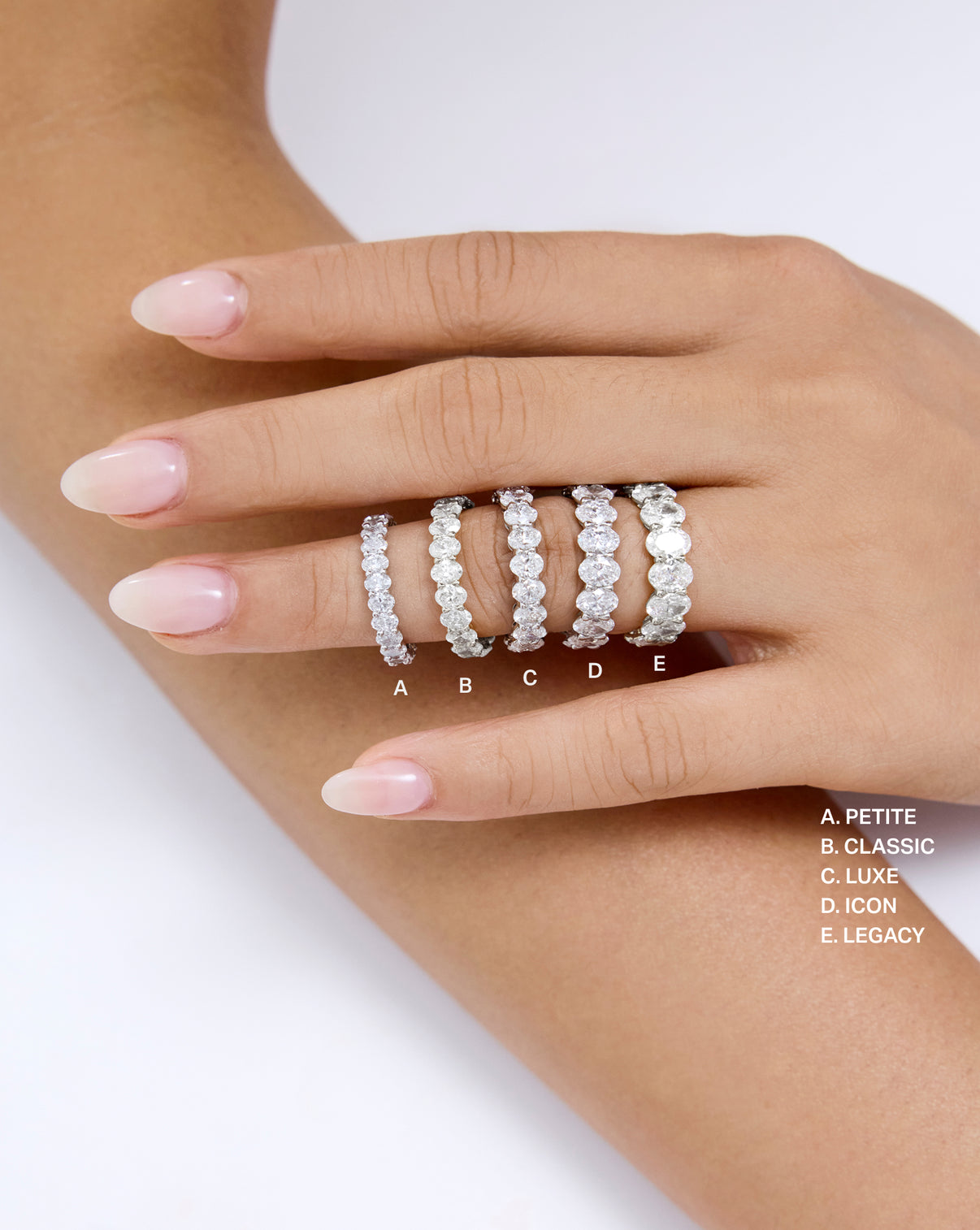 On hand comparison of 5 oval eternity diamond band sizes across petite, classic, luxe, icon, and legacy global