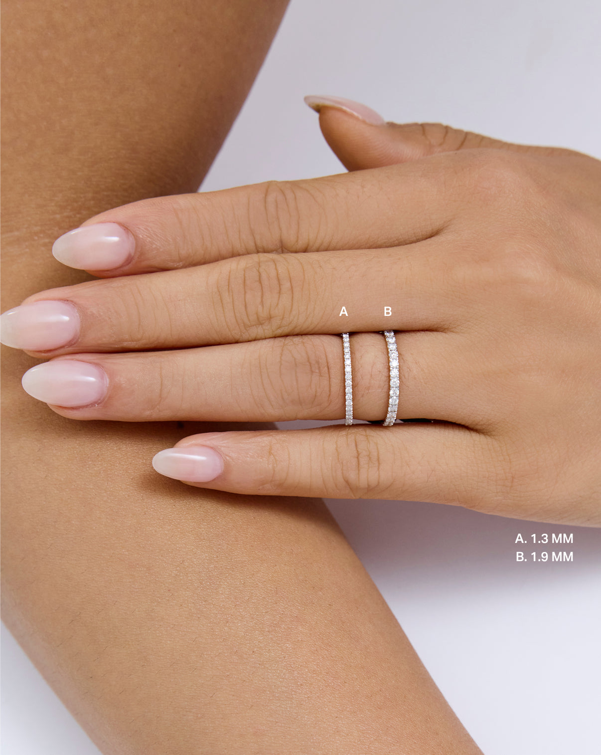 A close-up of a hand wearing two perfect pave rings, labeled A and B for 1.3 and 1.9 mm global