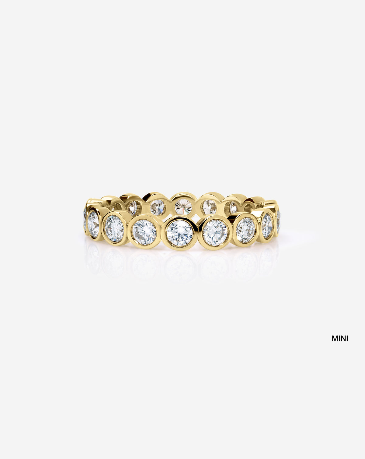 mini round bezel wedding band on white background 14k yellow gold