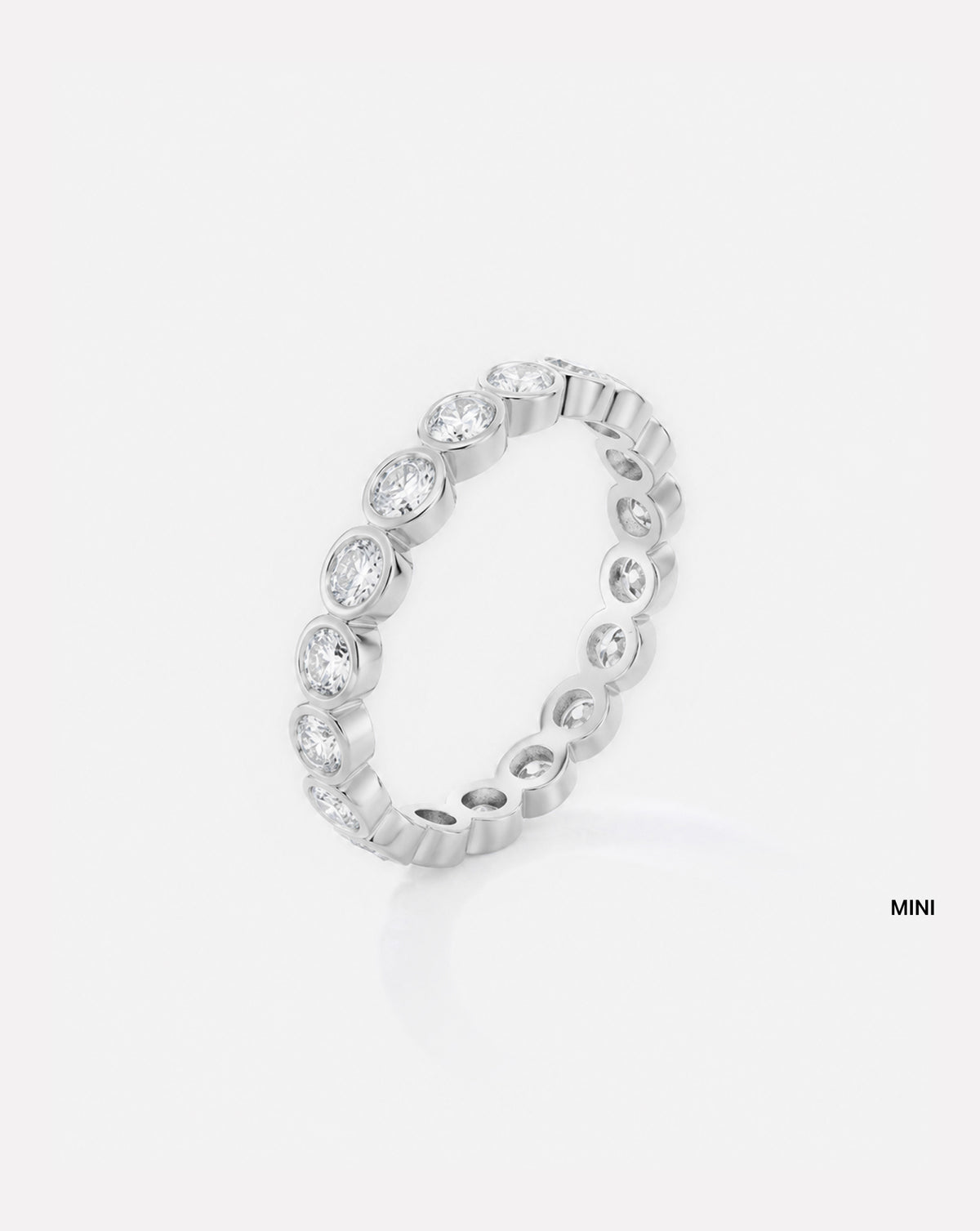 mini round bezel wedding band on white background platinum side view