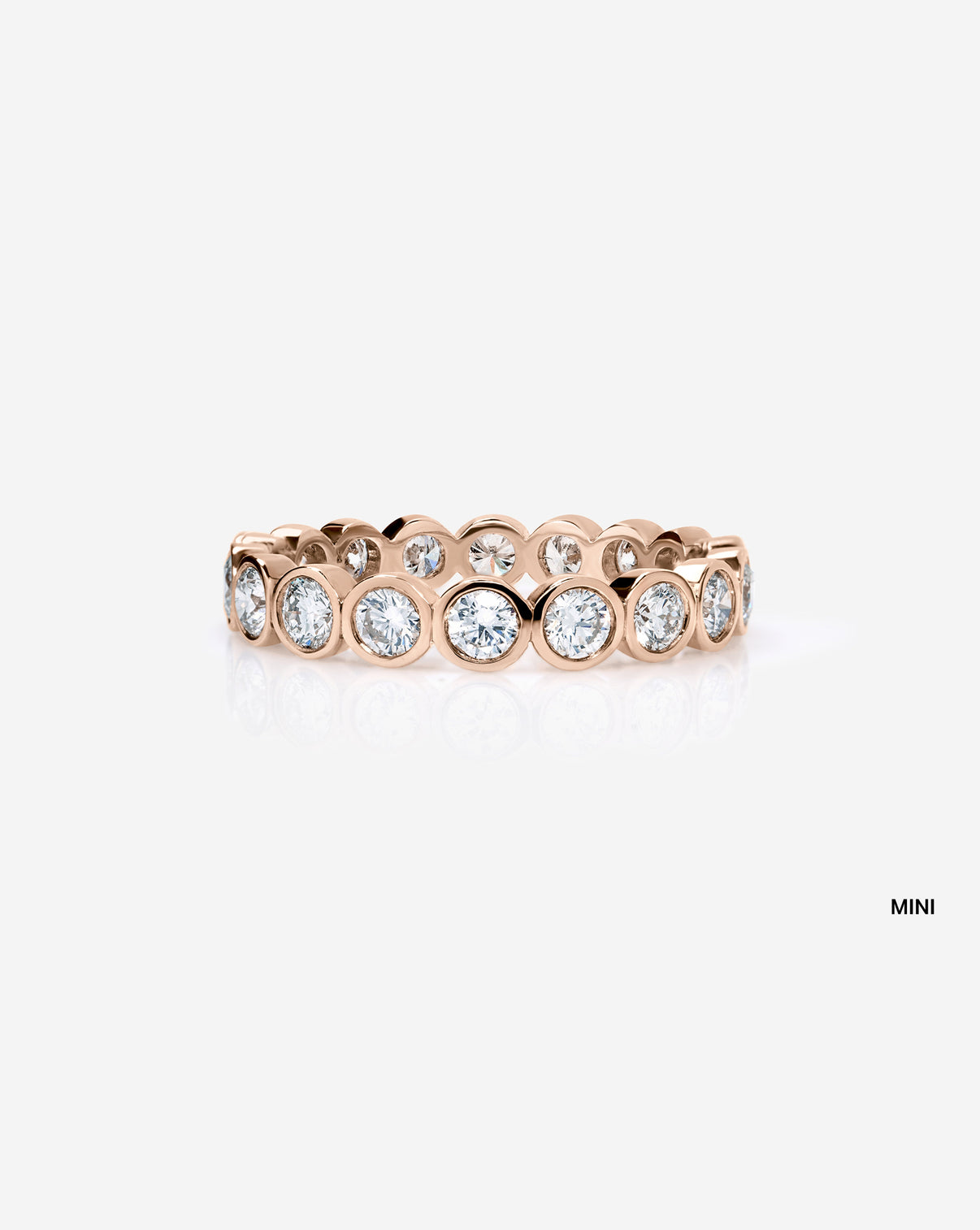 mini round bezel wedding band on white background 14k rose gold