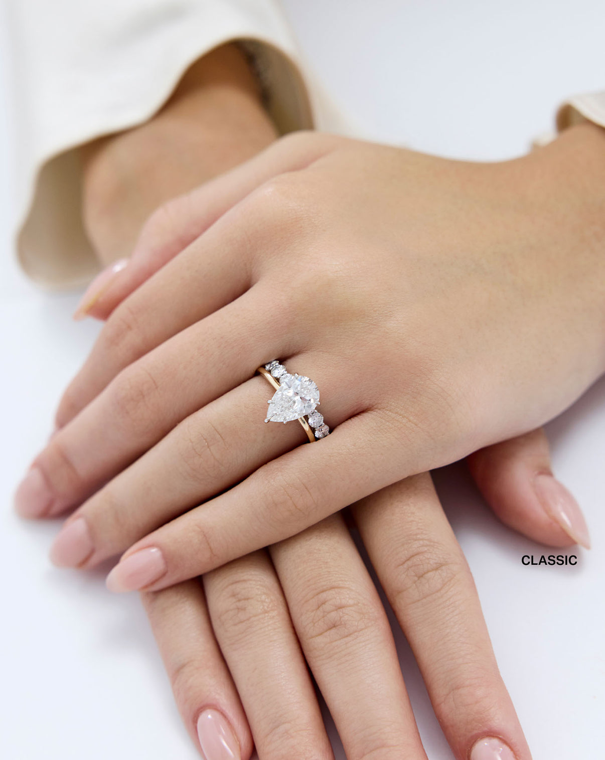 Round 3/4 Lab Diamond Band Classic shown styled with a pear engagement ring on model global