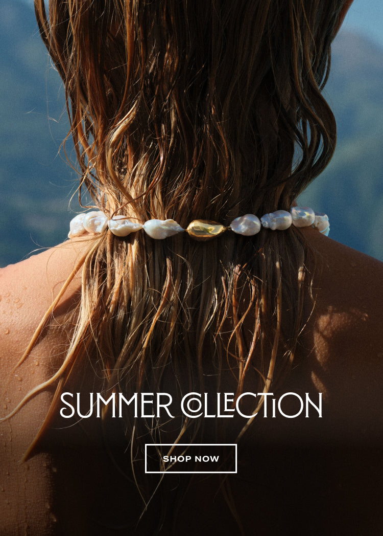 close up of the baroque pearl necklace around a model's neck with "summer collection shop now" text overlay