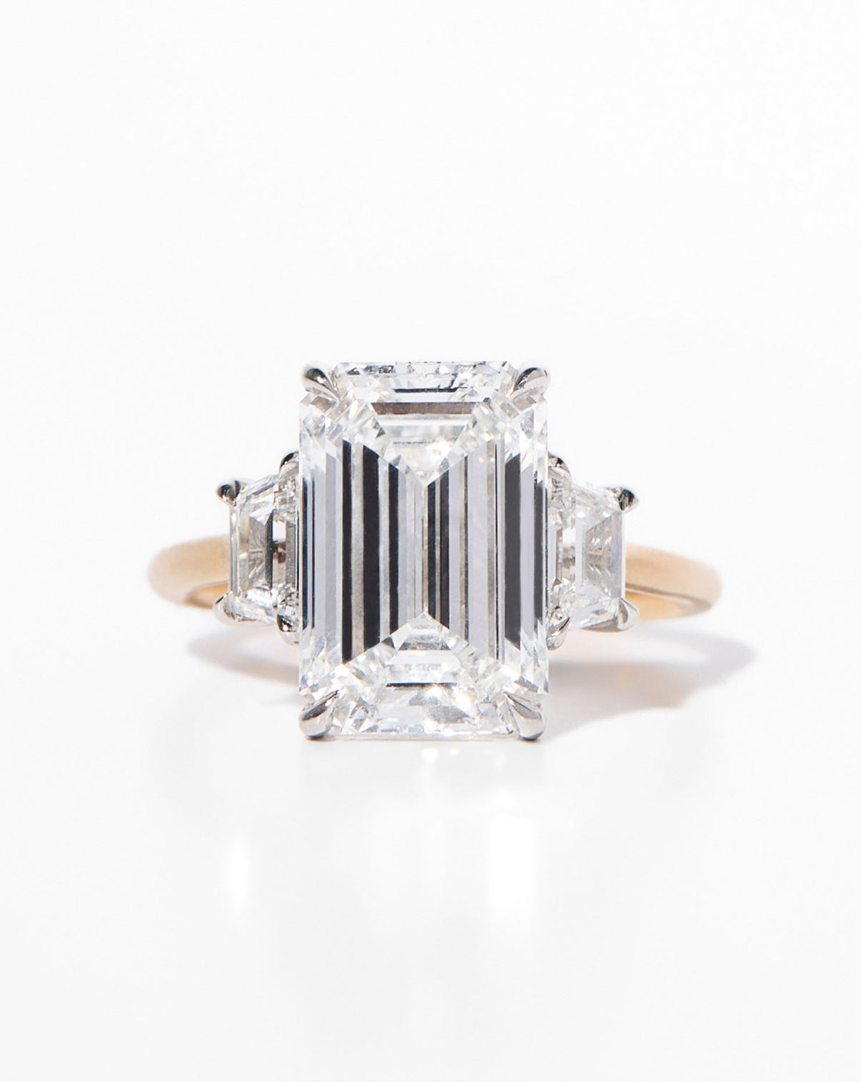 Ring Concierge Engagement Rings 5 carat Emerald in Yellow Gold Whisper Thin with trapezoid side stones close up view of emerald stone