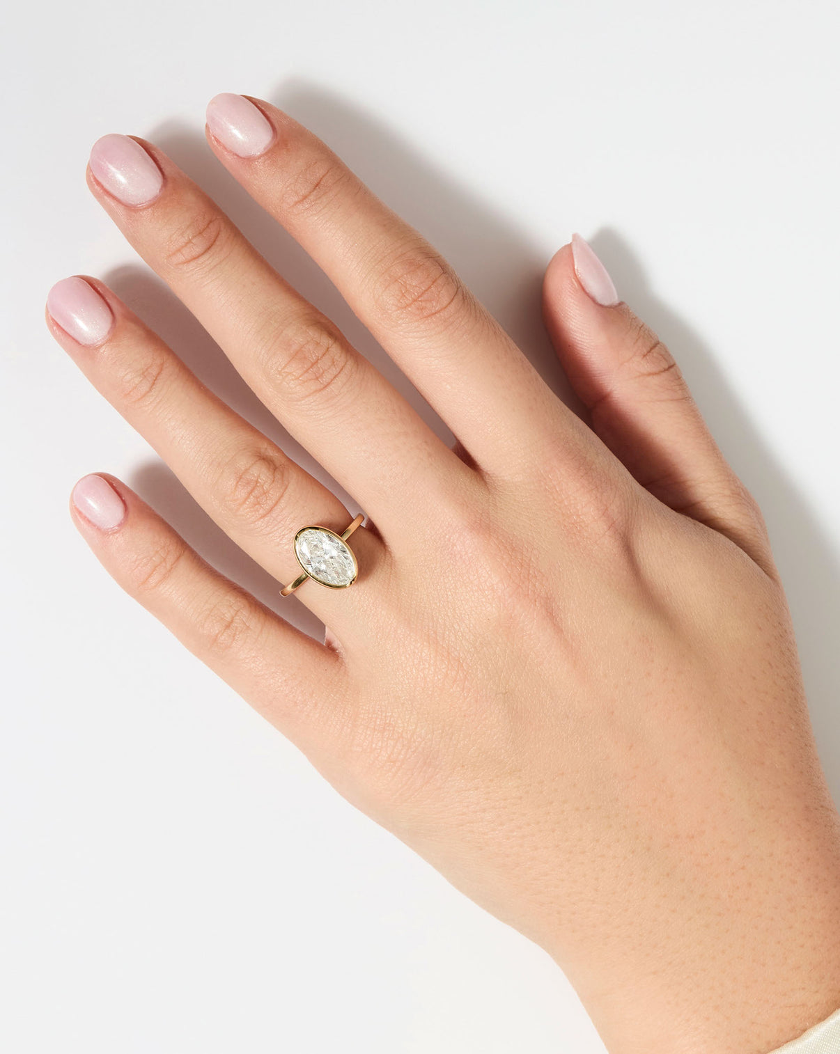 2 carat Oval Diamond Engagement Ring in Yellow Gold Whisper Thin Bezel shown on model