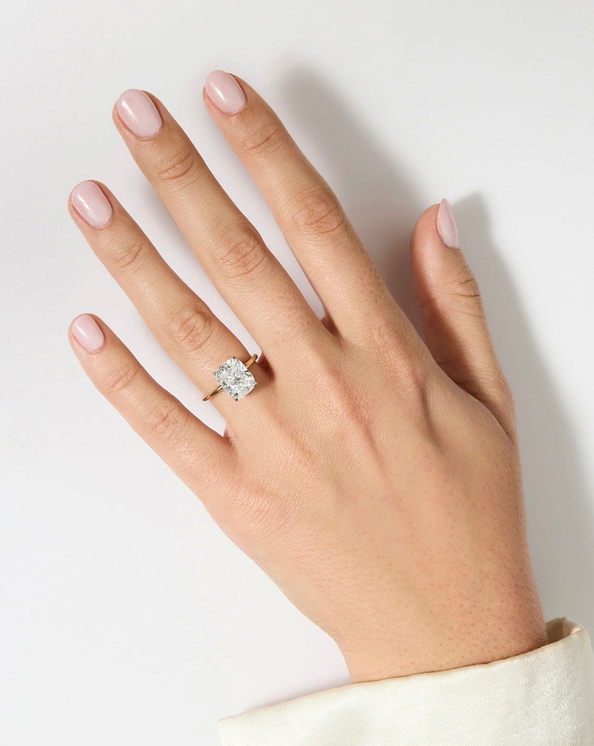 4 carat Cushion Diamond Engagement Ring in Yellow Gold Whisper Thin band with Platinum Prongs on model's hand