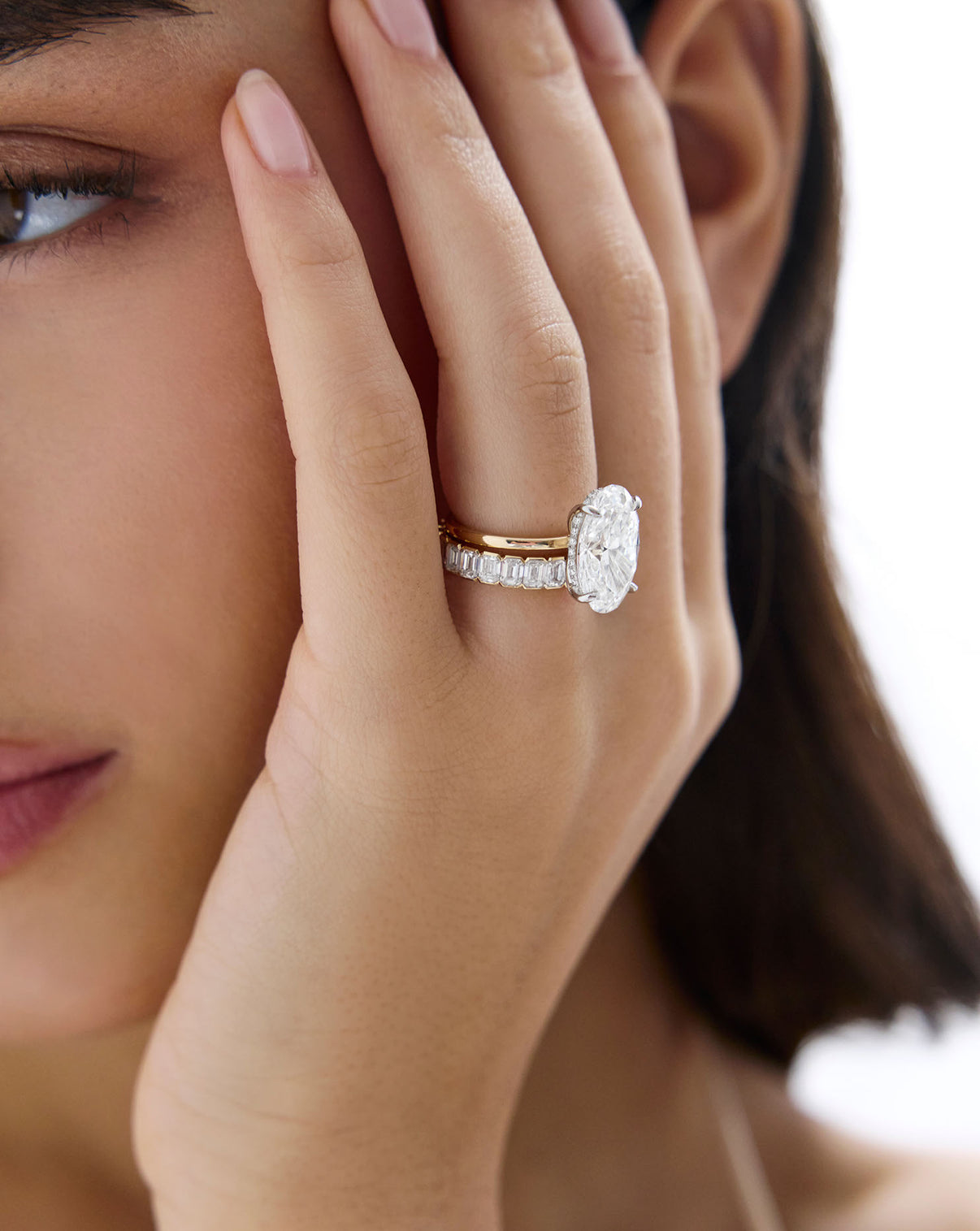 2 carat Oval Diamond Engagement Ring in Yellow Gold Whisper Thin Hidden Halo band with Platinum Prongs shown on model's hand styled with a diamond wedding band