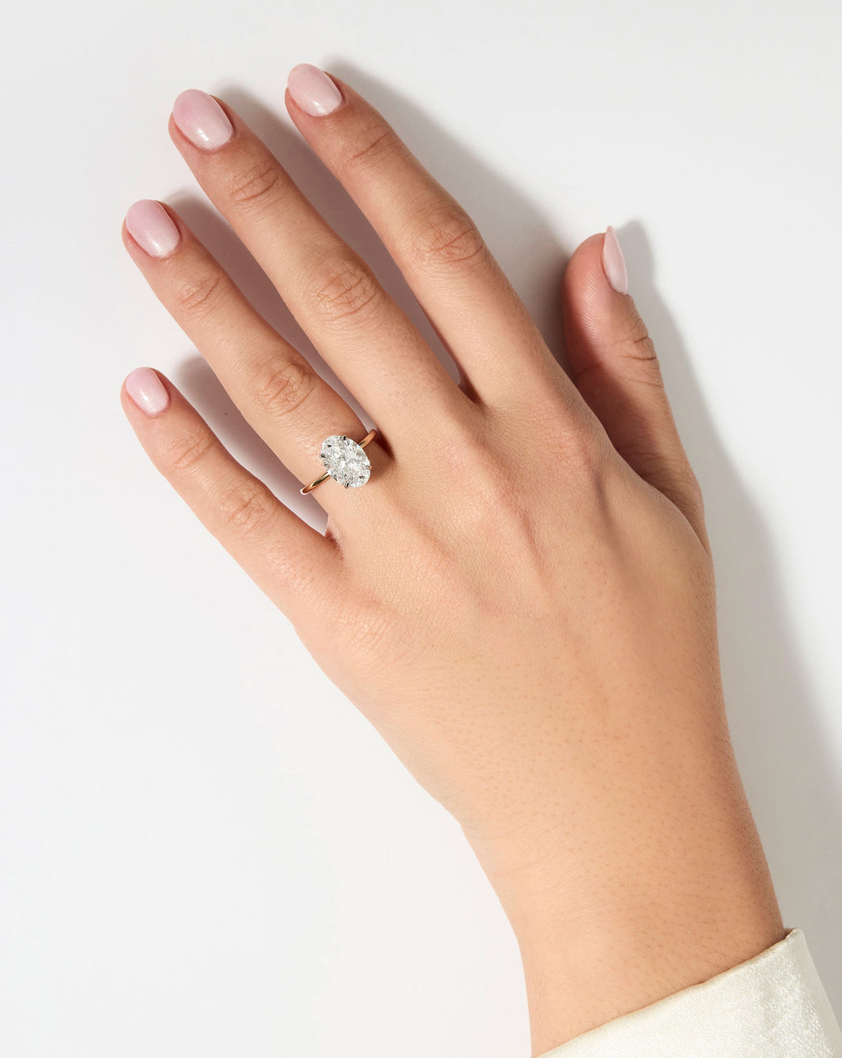 model wearing 3 carat Oval Diamond Engagement Ring in Yellow Gold Whisper Thin Hidden Halo band with Platinum Prongs
