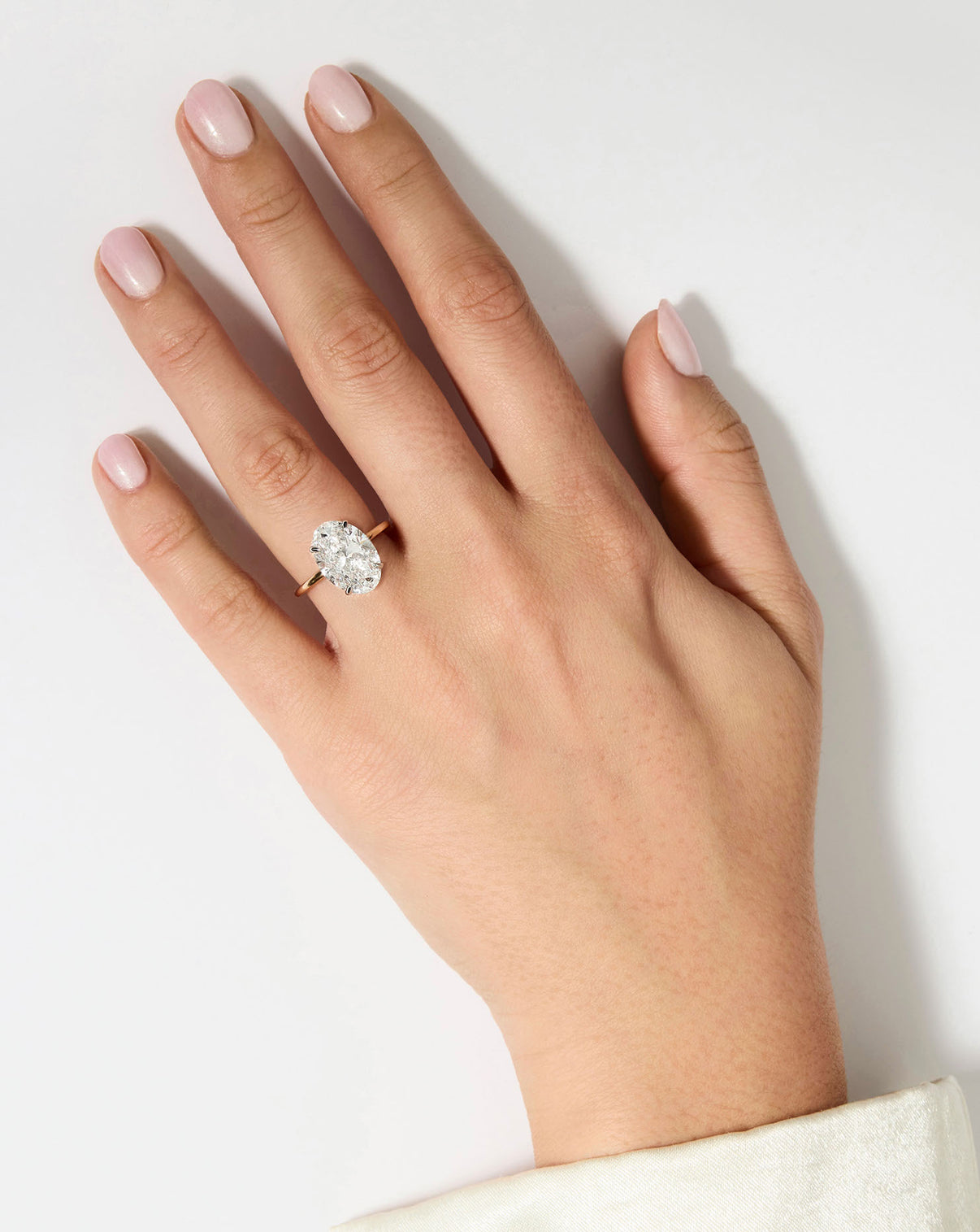 5 carat Oval Diamond Engagement Ring in Yellow Gold Whisper Thin Hidden Halo band with Platinum Prongs shown on model's hand