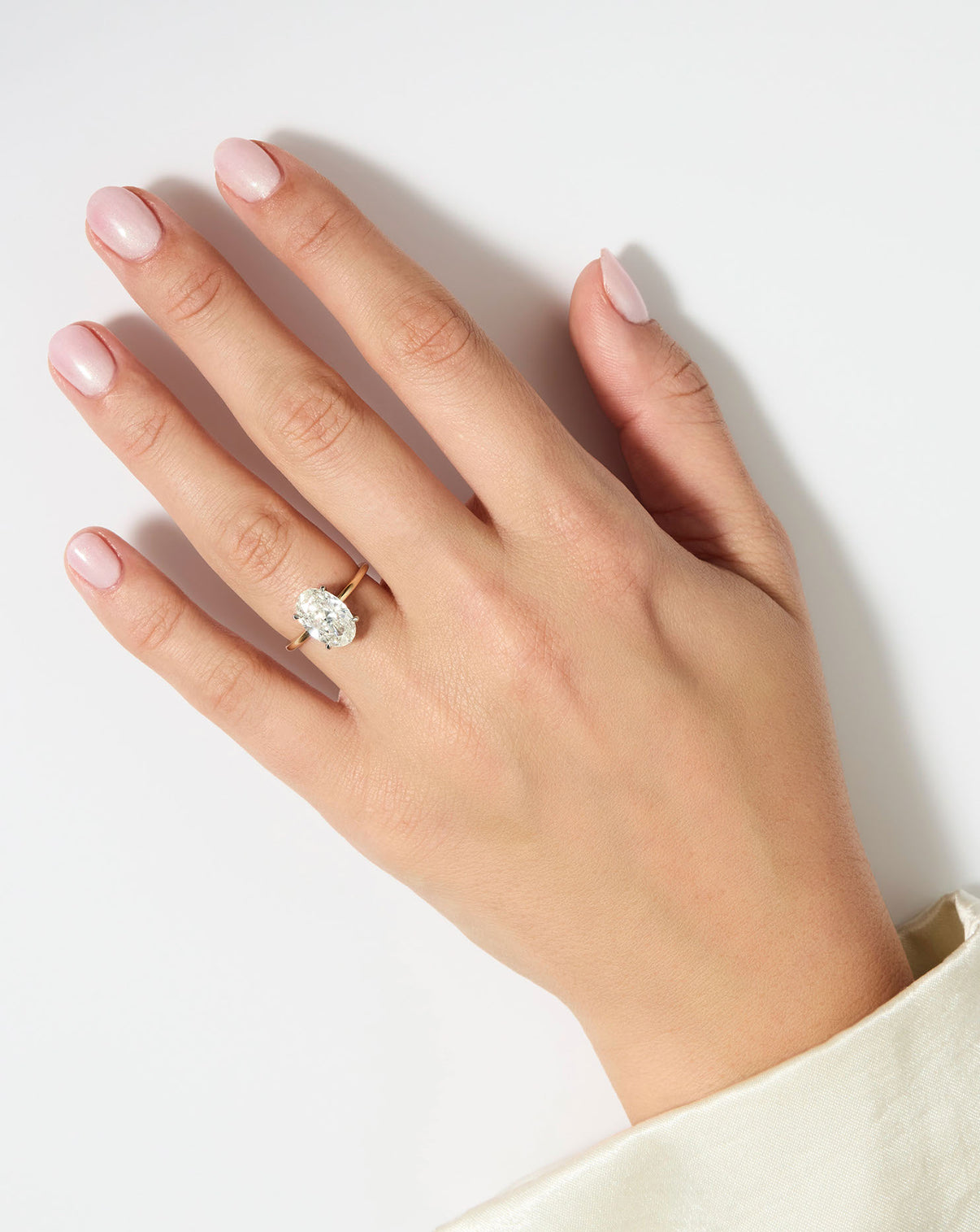 4 carat Oval Diamond Engagement Ring in Yellow Gold Whisper Thin band with Platinum Prongs shown on model's hand