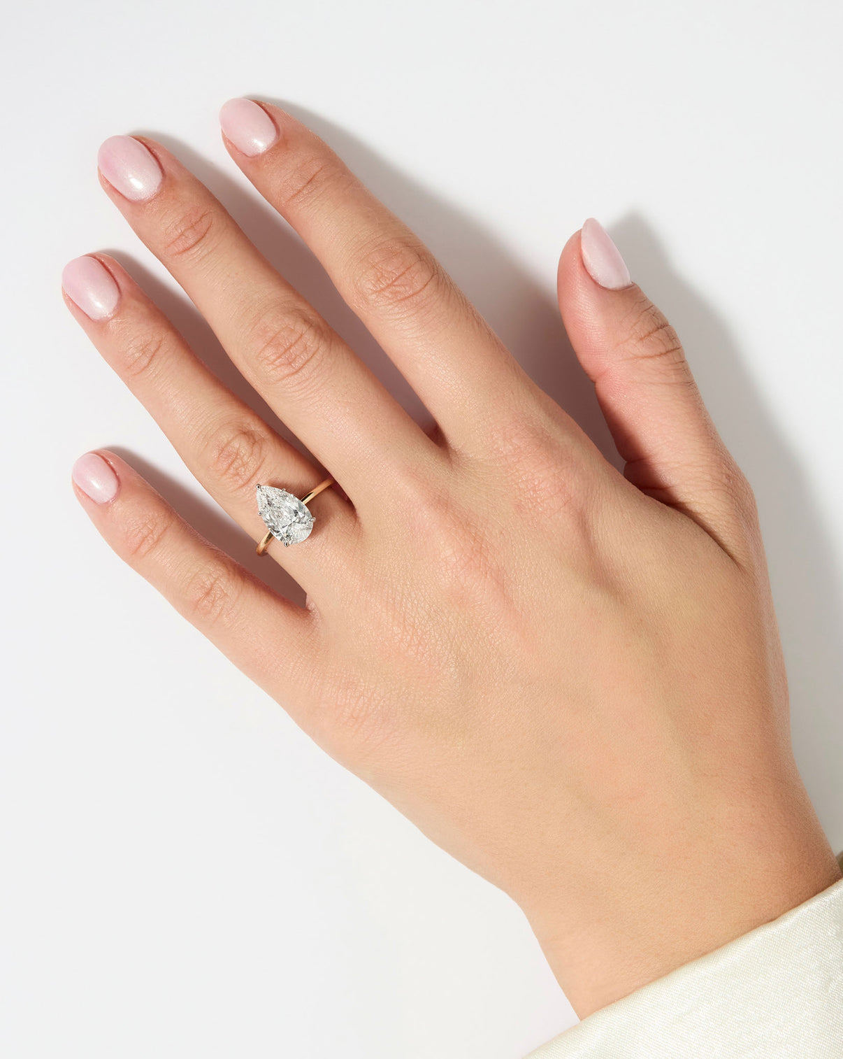 3 carat Pear diamond engagement ring with Yellow Gold Whisper Thin band and Platinum Prongs shown on model's hand