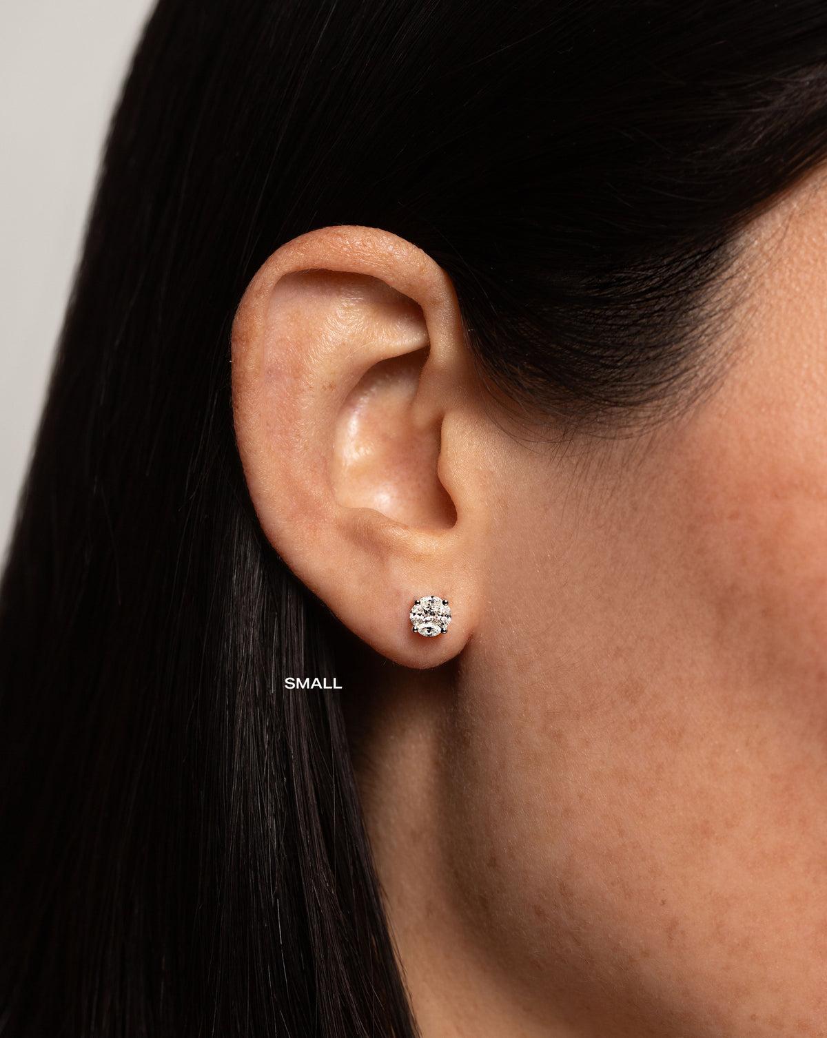 side view of model wearing round illusion diamond studs size small