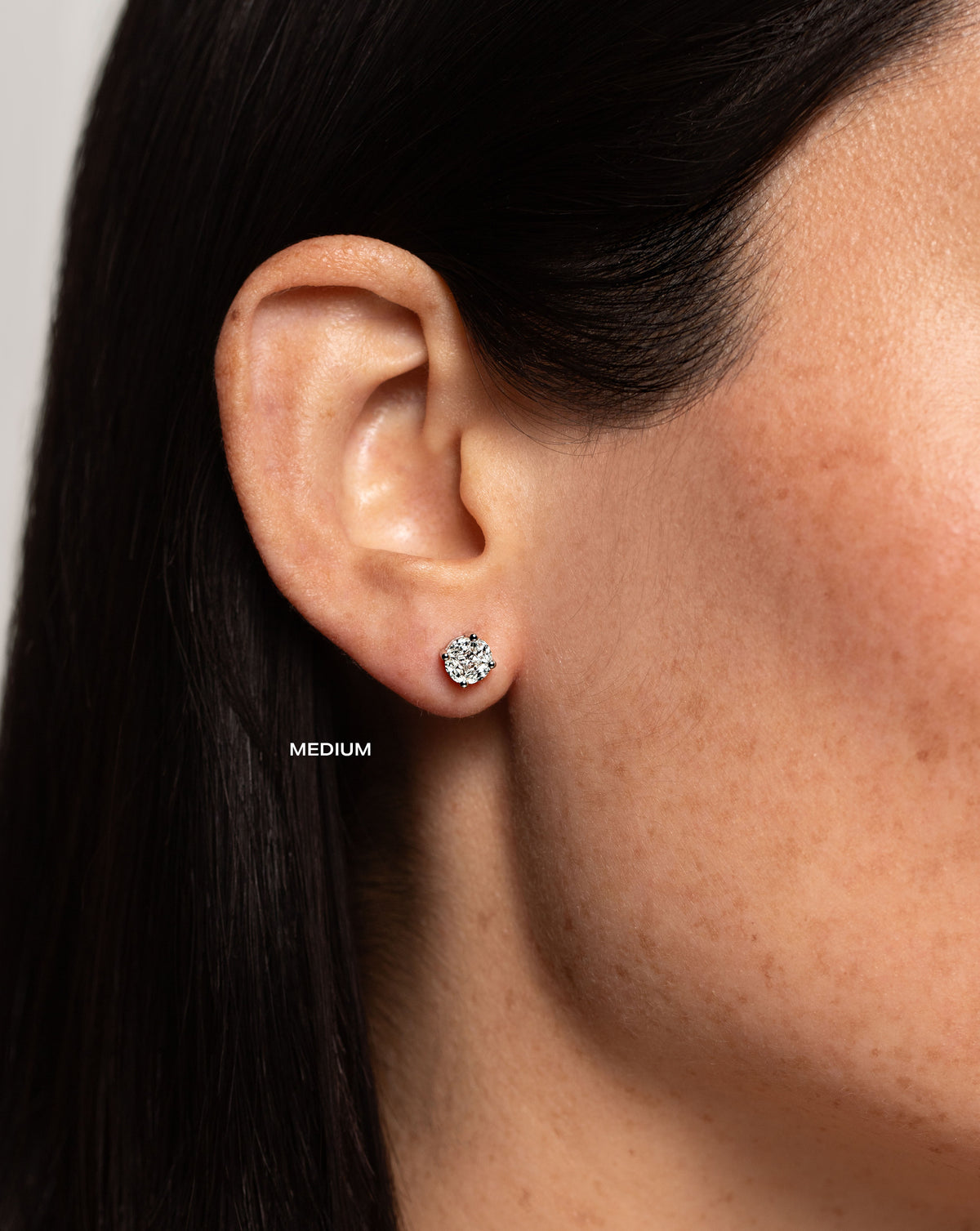 side view of model wearing round illusion diamond studs size medium