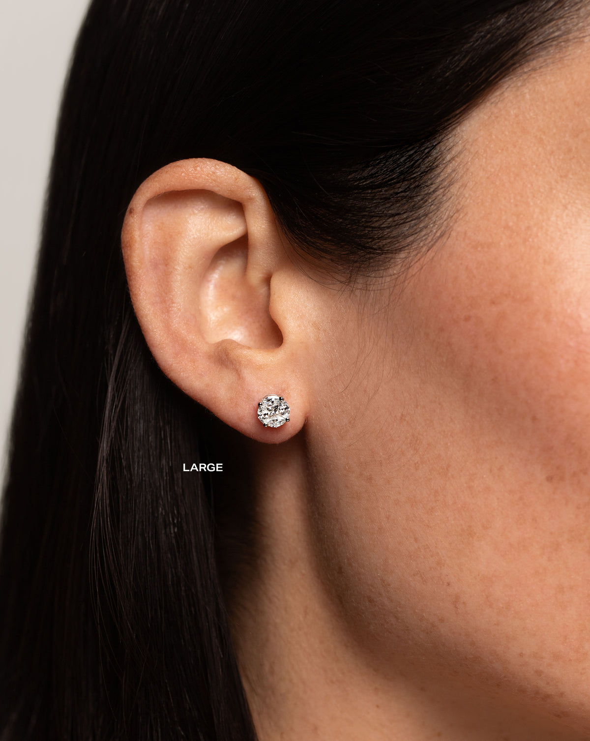 side view of model wearing round illusion diamond studs size large