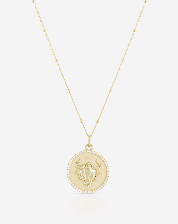 Zodiac Medallion Necklace flat lay in yellow gold Taurus