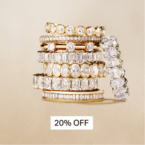 stacked diamond wedding bands in different shapes against a travertine background