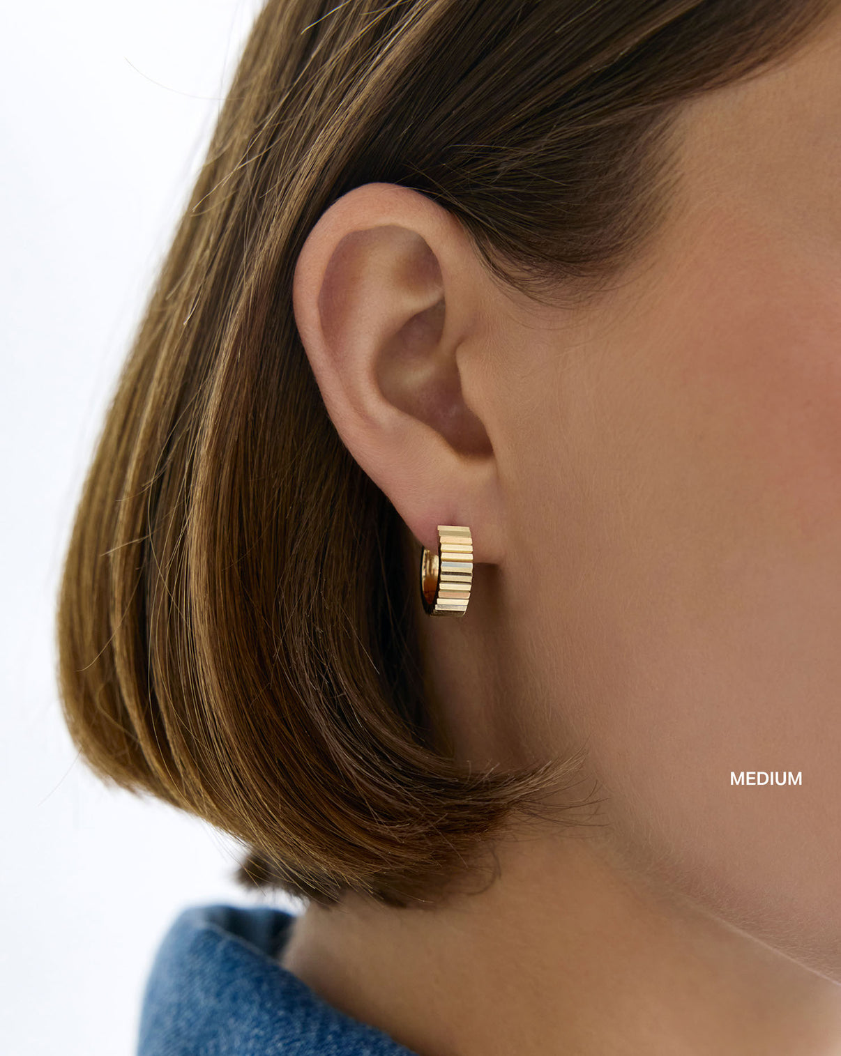 Wide Fluted Gold Hoops medium on model. global
