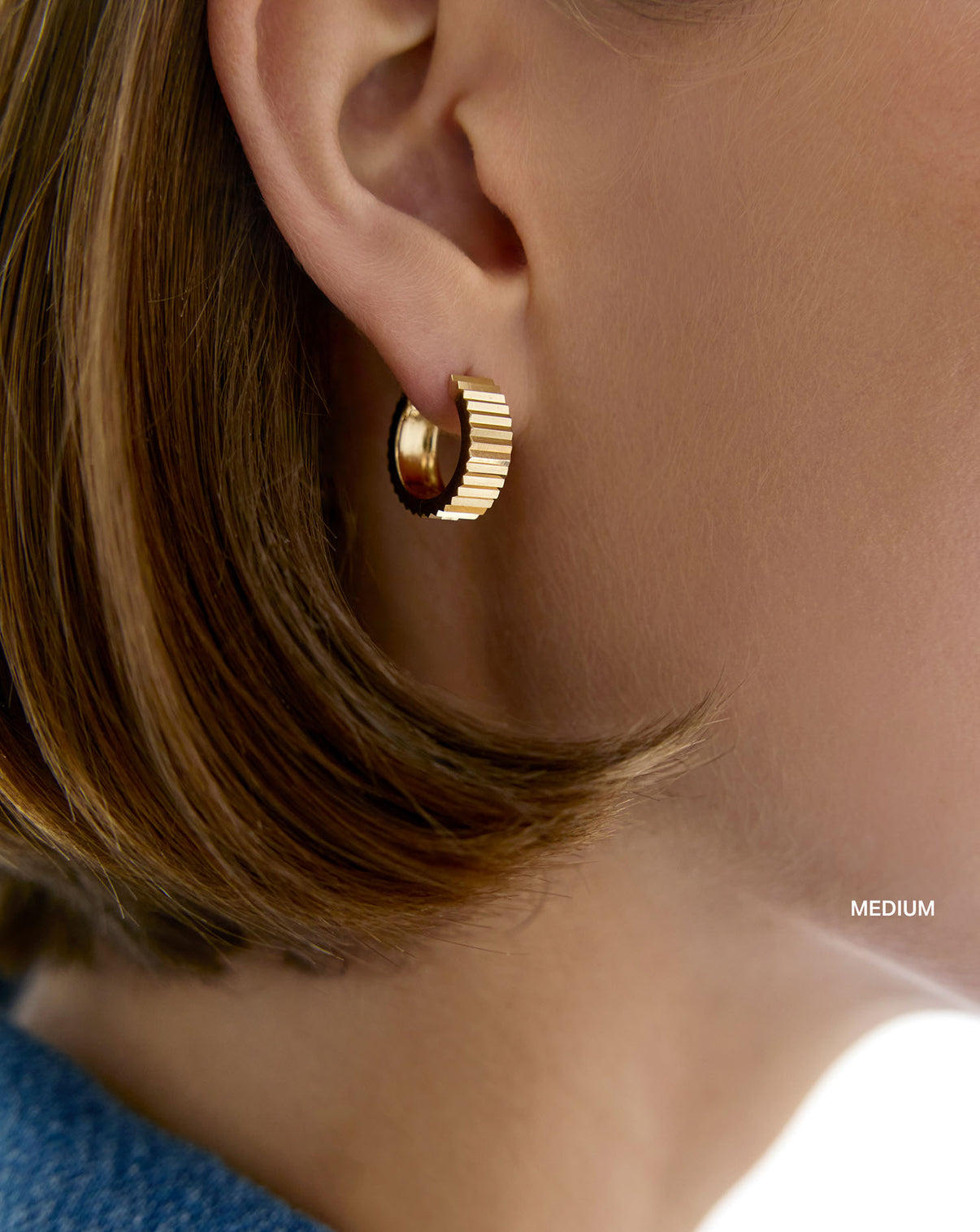 Wide Fluted Gold Hoops medium on model. global