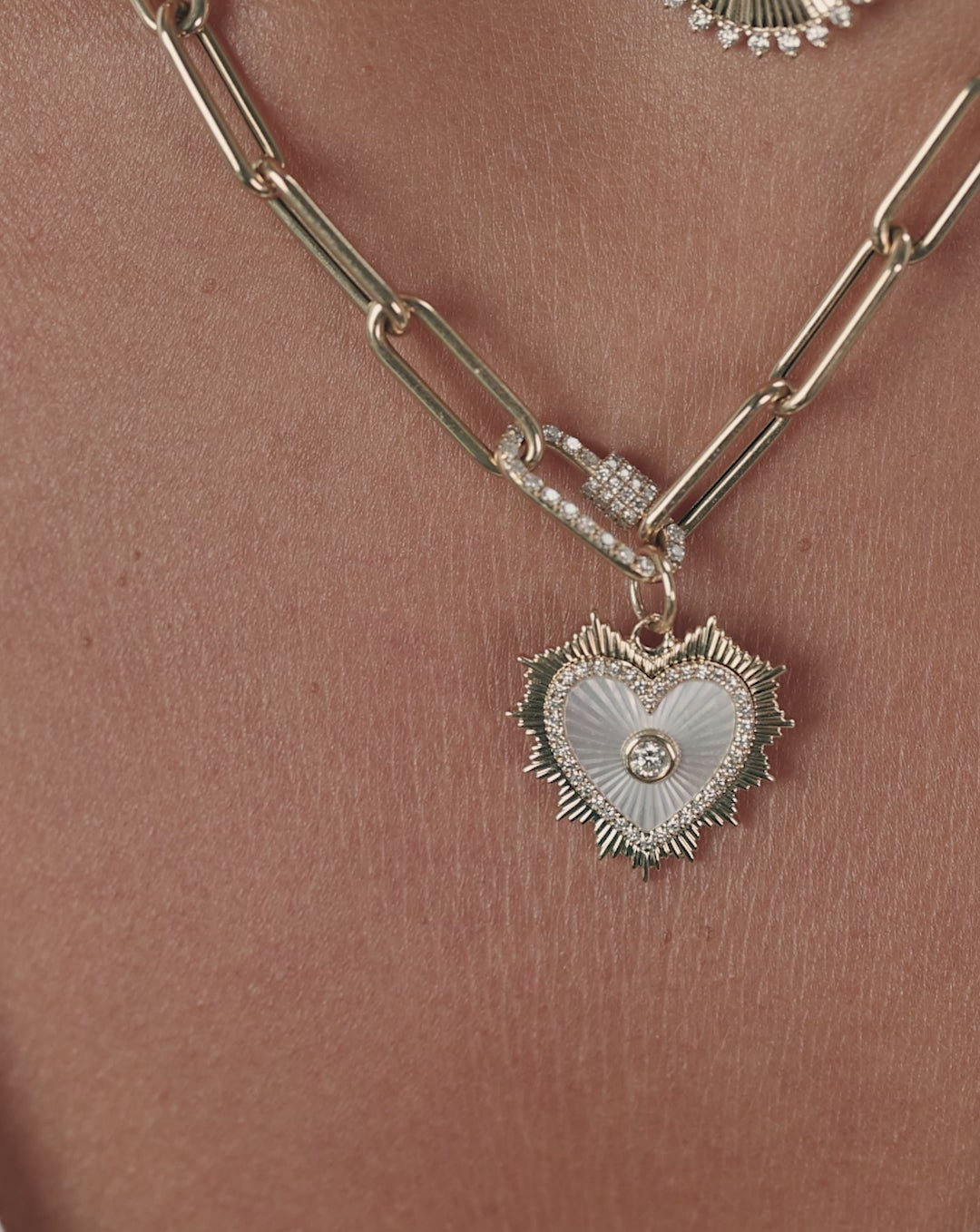 Fluted pearl heart pendant rotating to show textured gold surface and white pearl center
